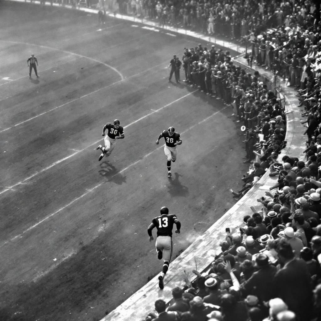 AI generated: create an image of an nfl wide receiver set in the 1950s running near the touchline as a defender ch...