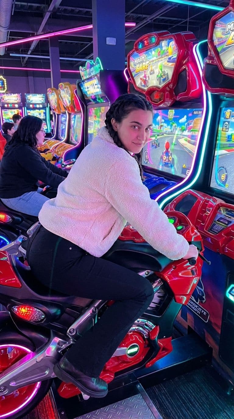 AI generated: Ultra-realistic photo of a young woman with dark braided hair sitting on an arcade motorcycle racing...