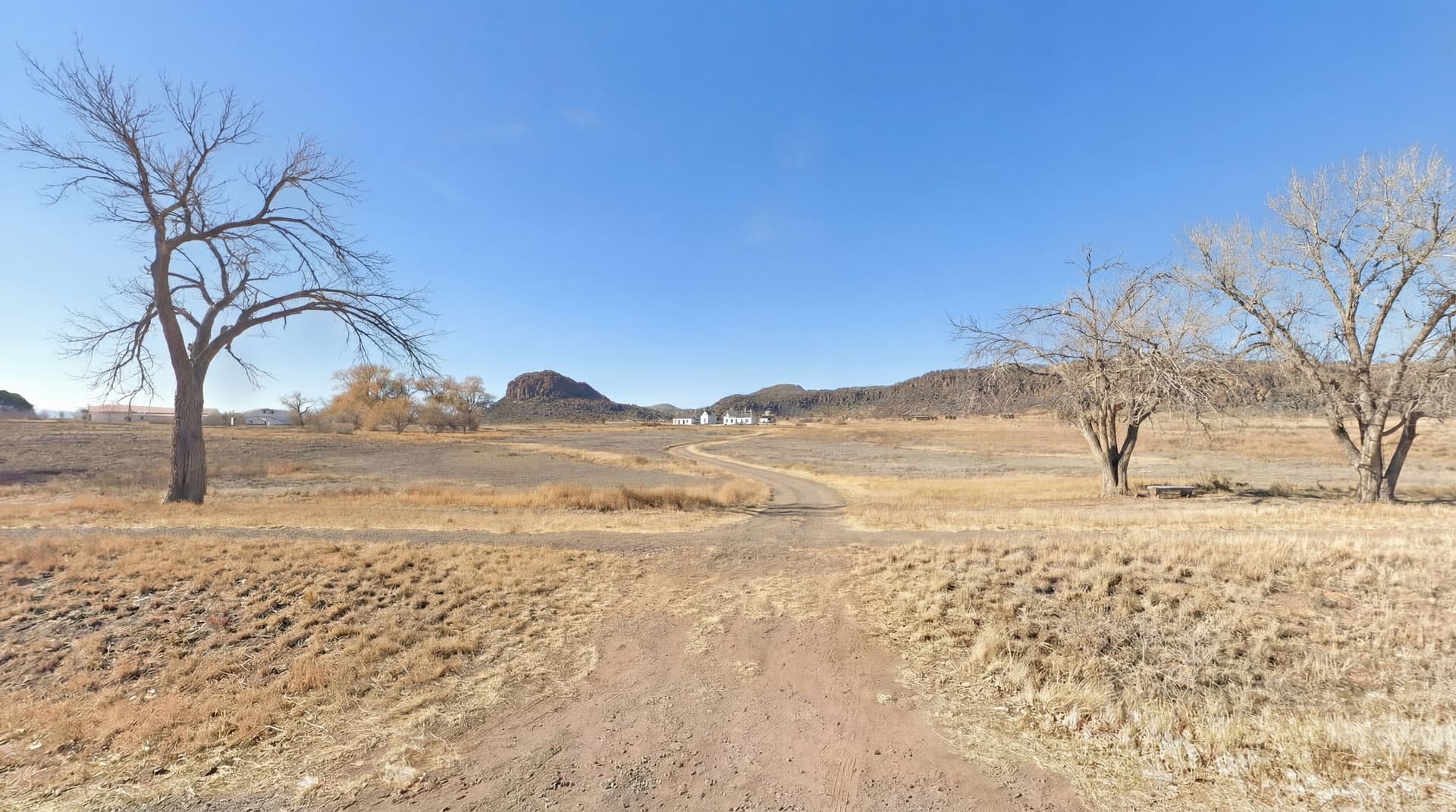 AI generated: delete the fence. add the existing road in the distance maintain sight line towards the fort davis o...