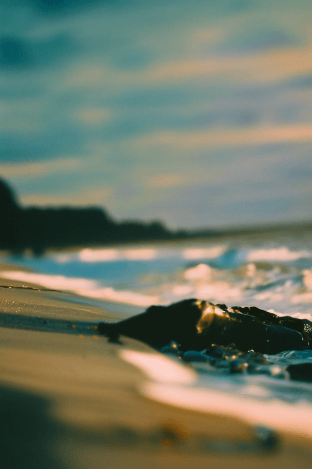 AI generated: waves crashing on the beach at sunset, tilt-shift, golden hour, vibrant colors, kodak ektar 100, fil...
