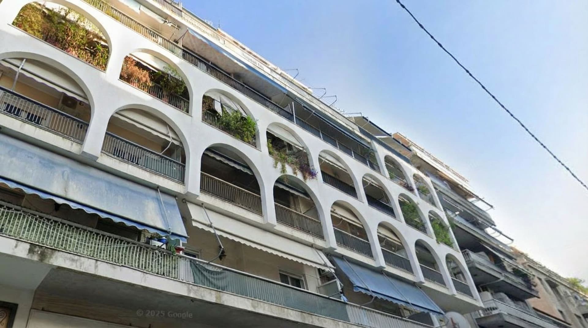 AI generated: Add white continuous arches in the facade of the balconies that hold vegetation. 