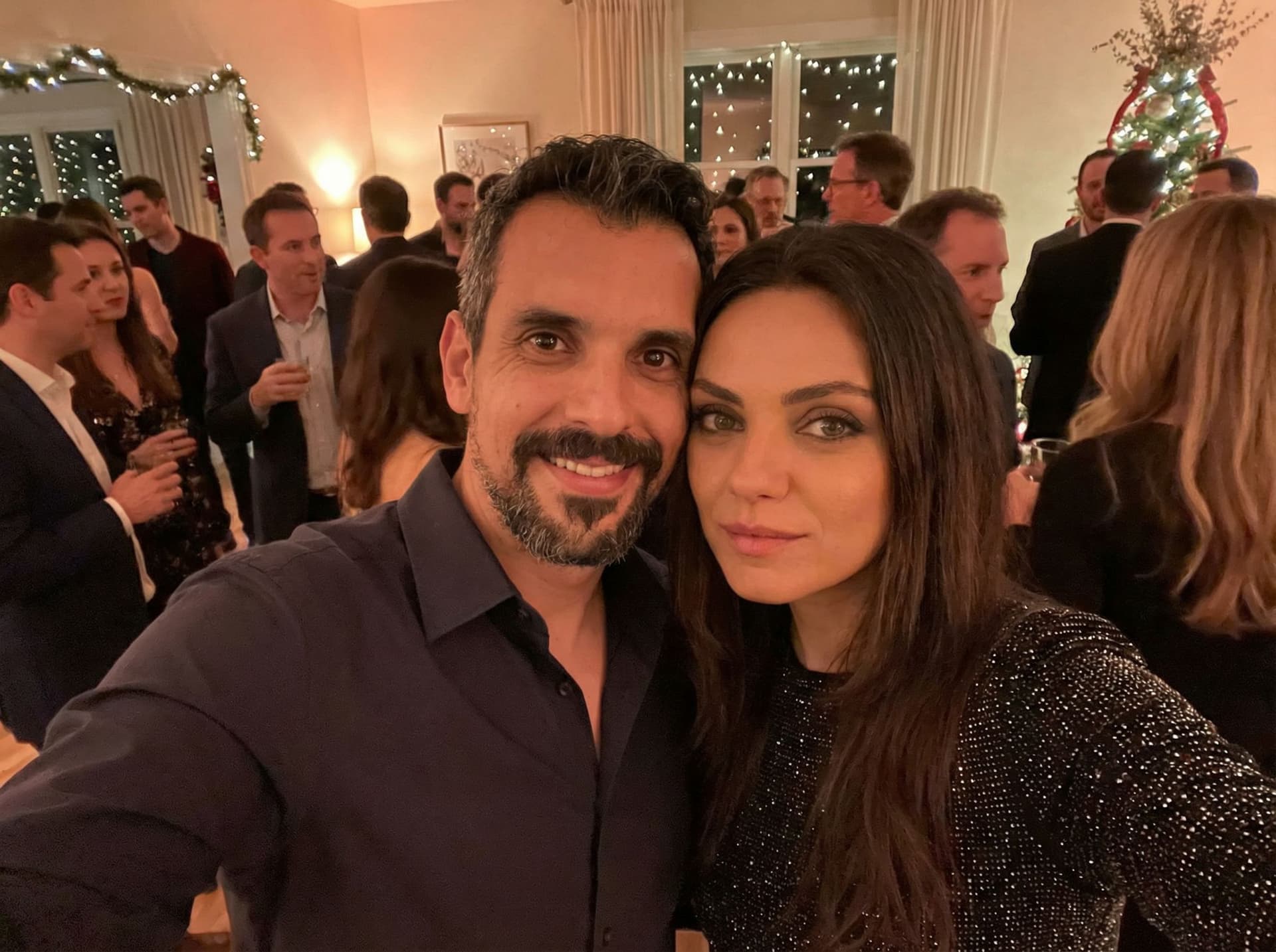 AI generated: The person in the photo next to Mila Kunis at a party, a selfie-style photo.