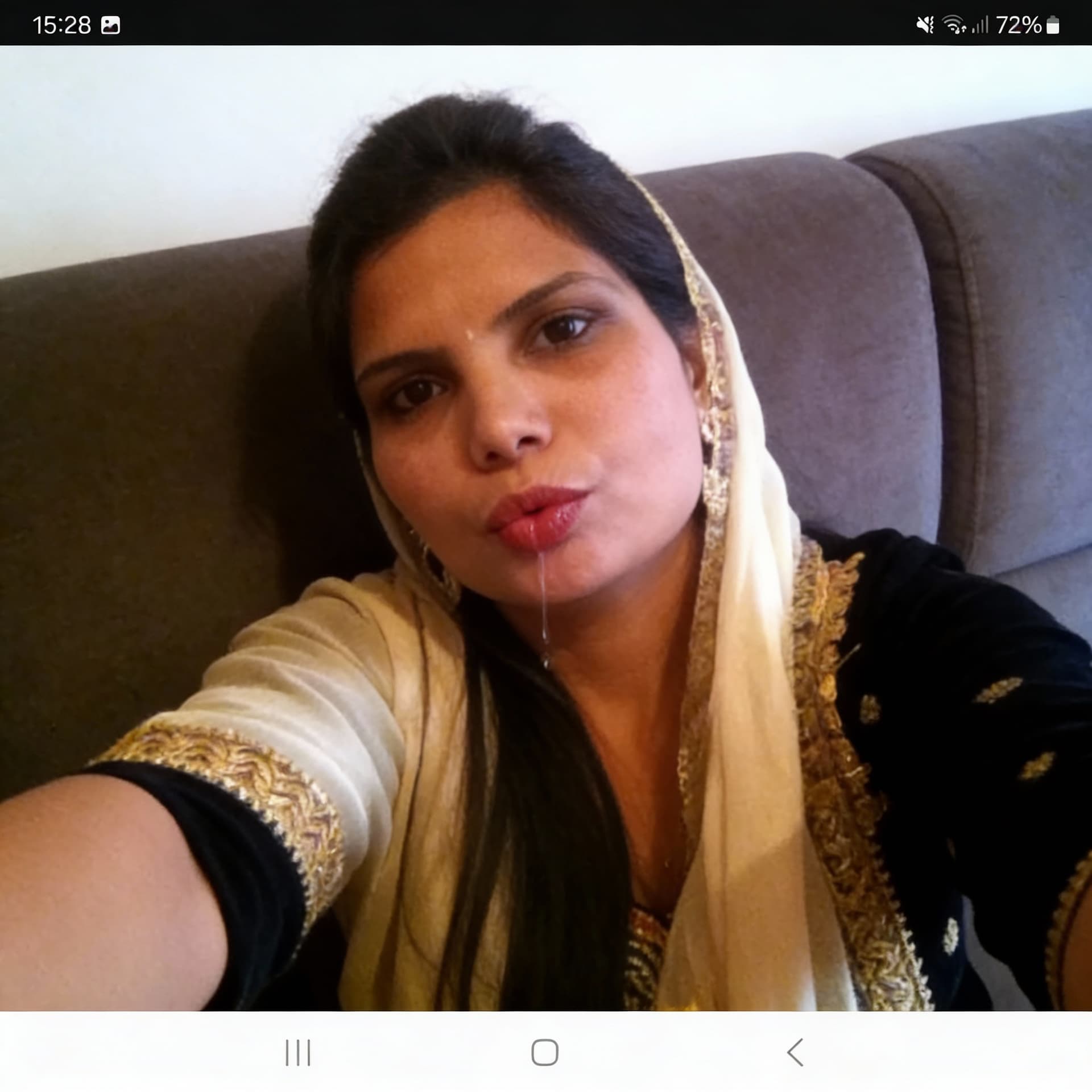 AI generated: Takes a selfie while sitting on  a couch, sticking lips out with saliva