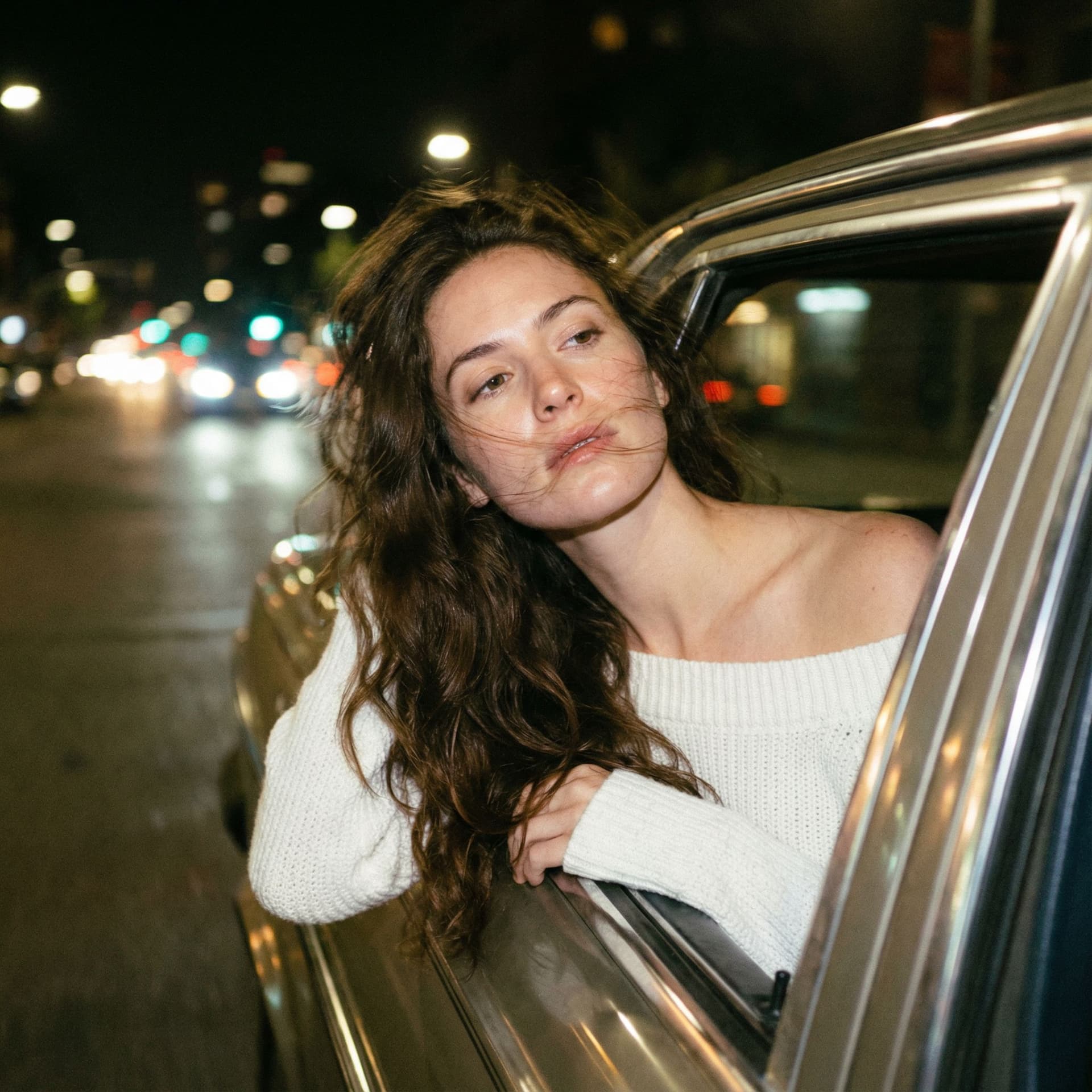 AI generated: Create a photo of me leaning my back out the window car like a dark dreamy blurry vintage windy

nig...