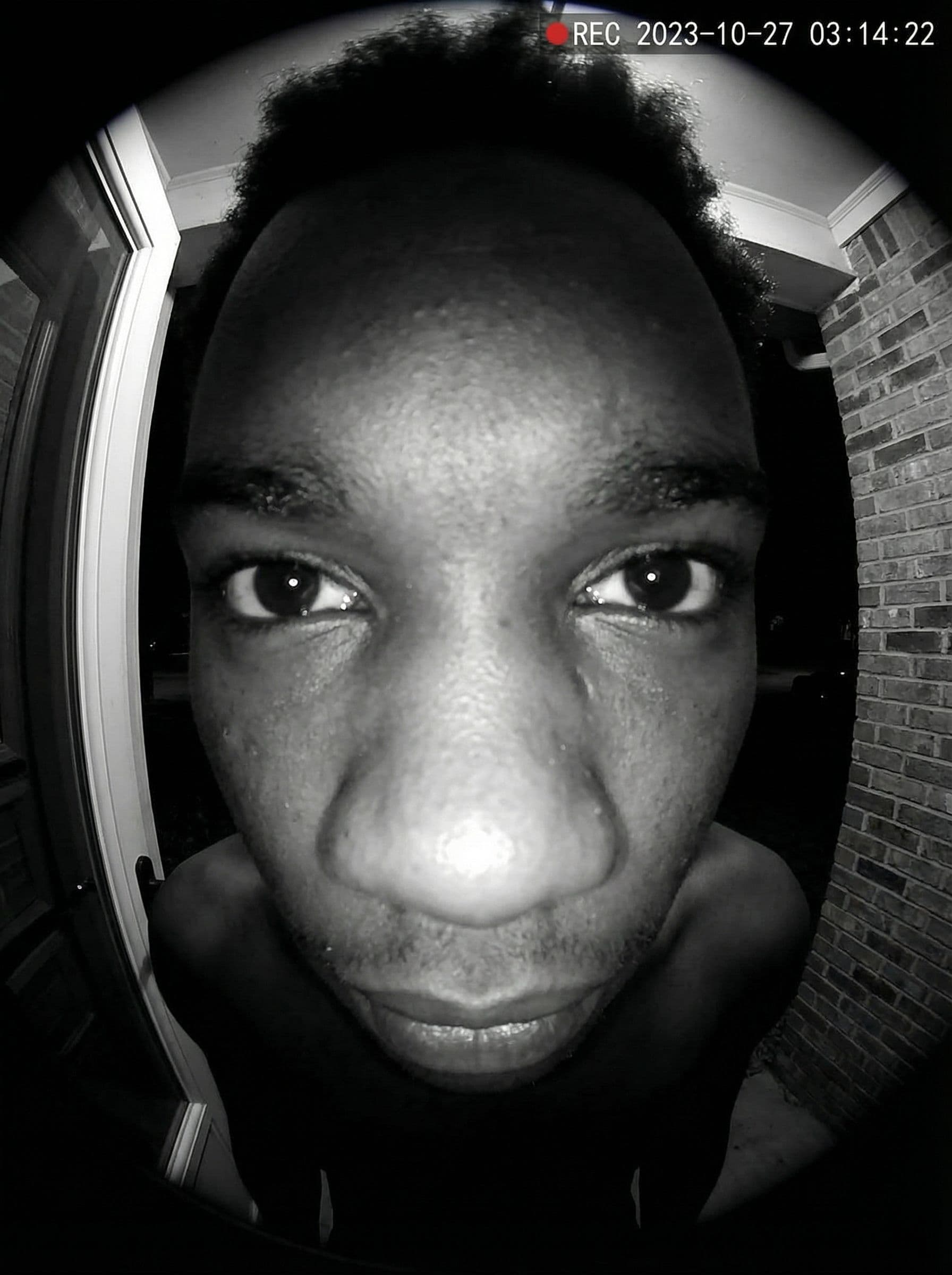 AI generated: Ultra-realistic doorbell camera POV, extreme fisheye distortion, face extremely close to the lens, e...