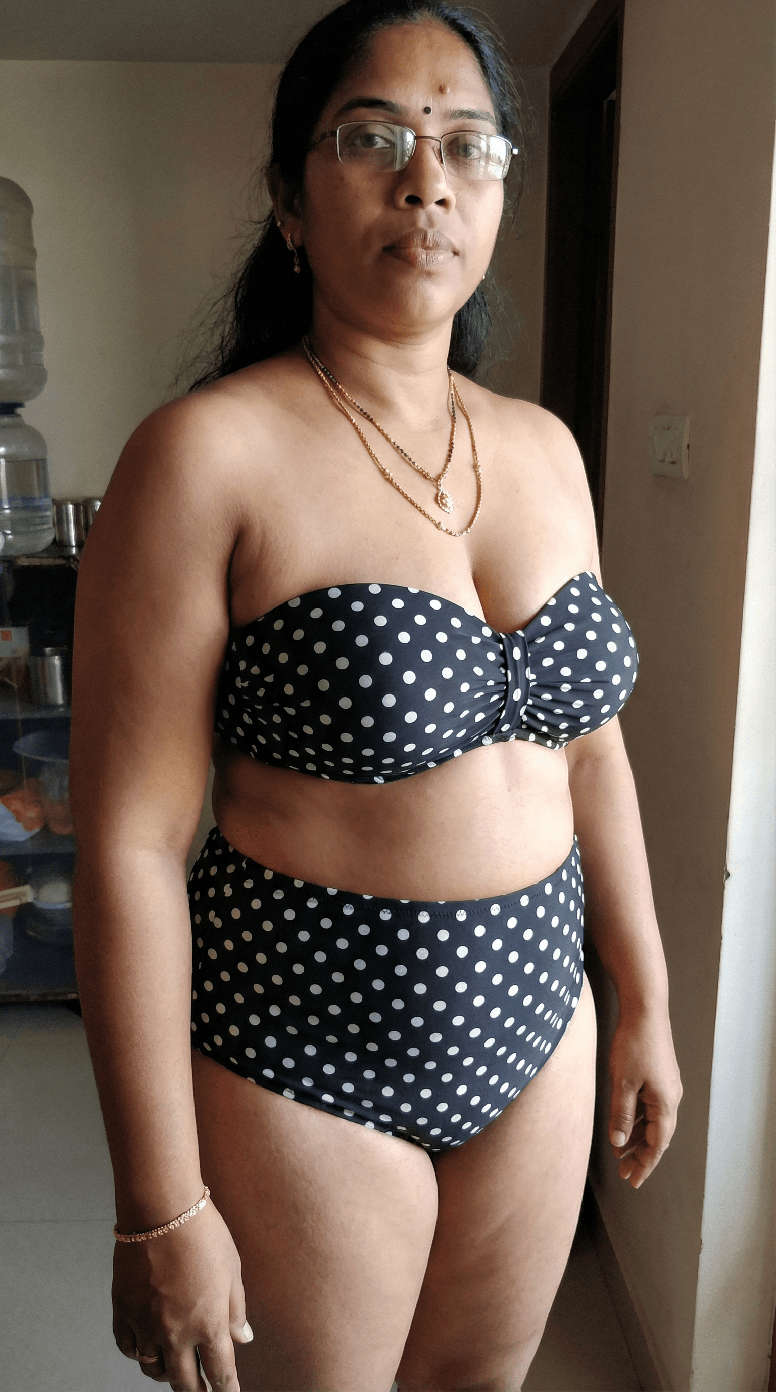 AI generated: She wears a retro strapless polka-dot bikini,top stretched tightly across her chest,neckline cut low...