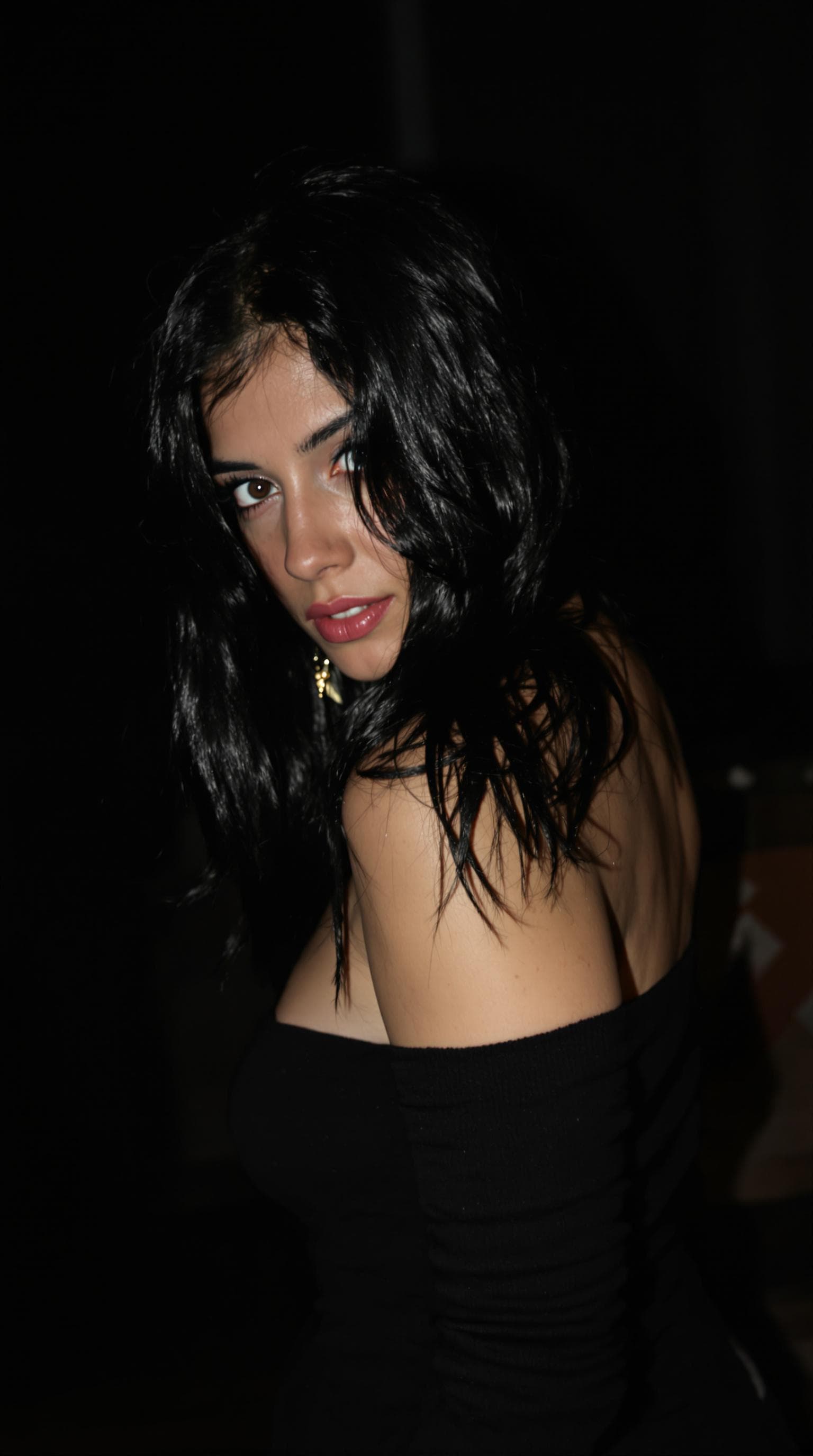 AI generated: 18-year-old woman, black hair, light blue eyes, tanned white skin, thin body, wearing black clothes ...
