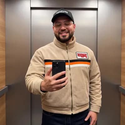 AI generated video: A man is standing in an elevator taking a mirror selfie. He is wearing a light beige corduroy zip-up...