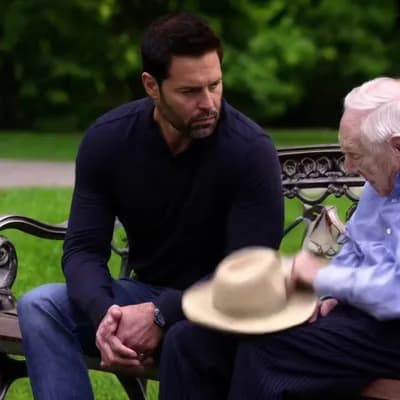 AI generated video: (Seconds 1-2) A man sits in a park, watching an old man struggling to pick up a hat that has been bl...