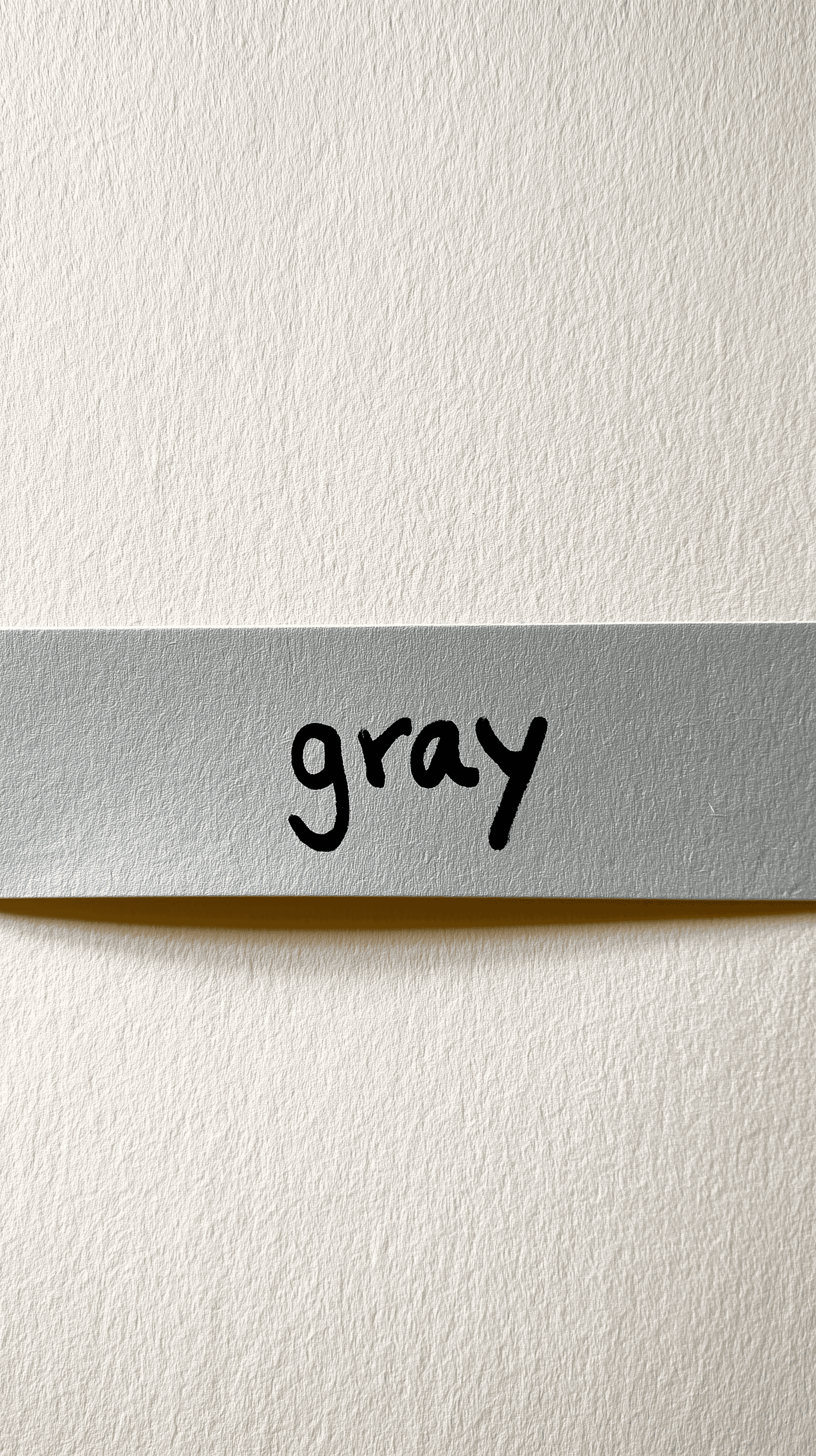 AI generated: photography, flat lay, horizontal strip of pale gray tape, handwritten black permanent marker text "...
