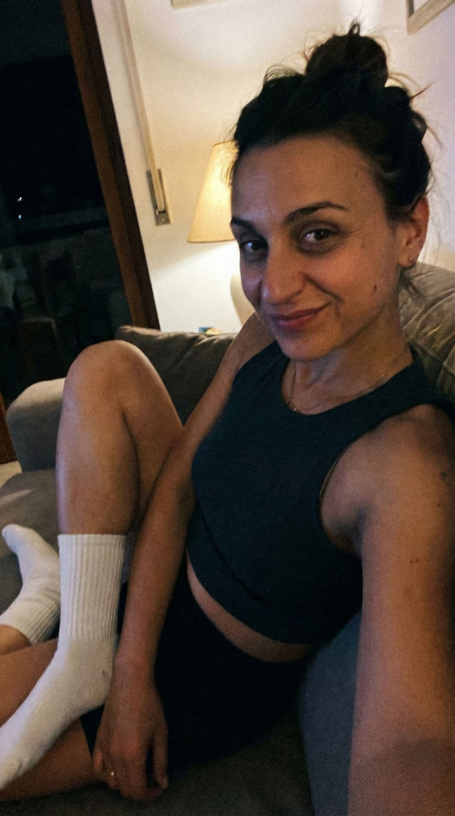 AI generated: on a couch, teasing looking, wearing a cropped tanktop and white socks, sloppy snapshot close view, ...
