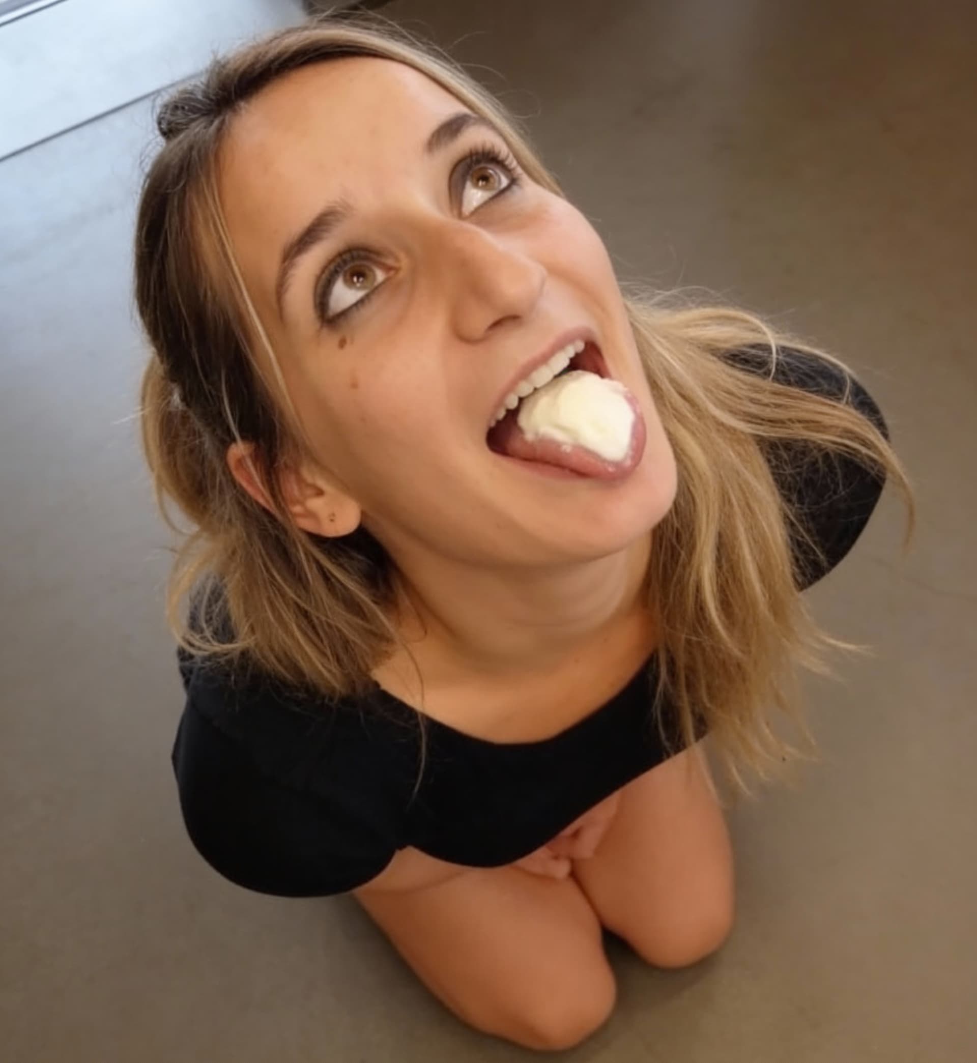 AI generated: iPhone selfie taken from a high overhead angle. kneels low, tilting her head back playfully with her...
