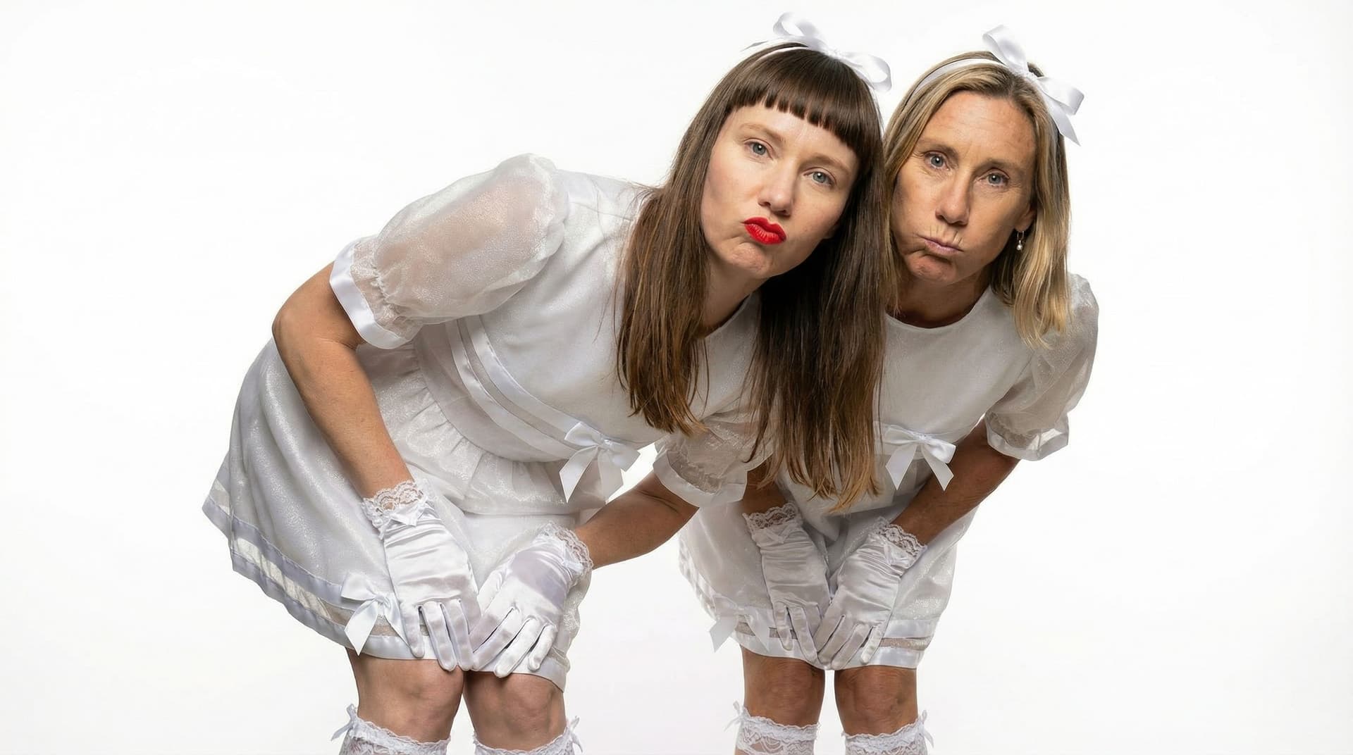 AI generated: 
Show the two subject's one behind the other, both leaning forwards and looking at us with a pouting...