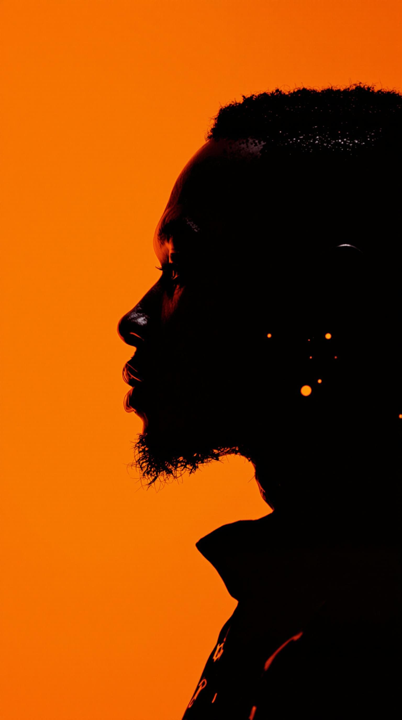 AI generated: photography, portrait of contrast, profile silhouette of a cyborg black man, vibrant orange backdrop...