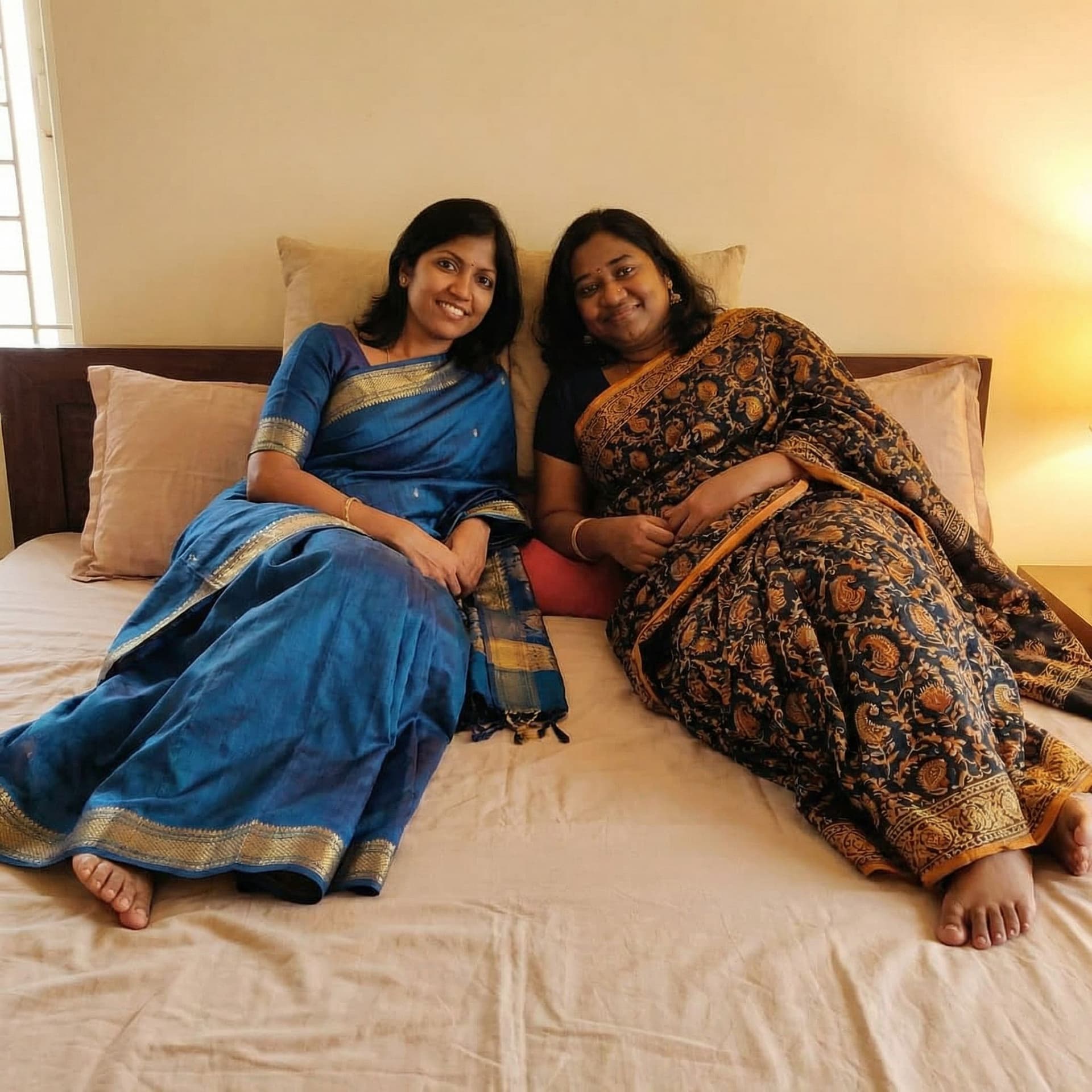 AI generated: Change their dress to saree and they both laying on a bed 