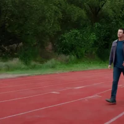 AI generated video: the man in the photo walks in a sports trac  a dinosaur appears and  the man greets it
