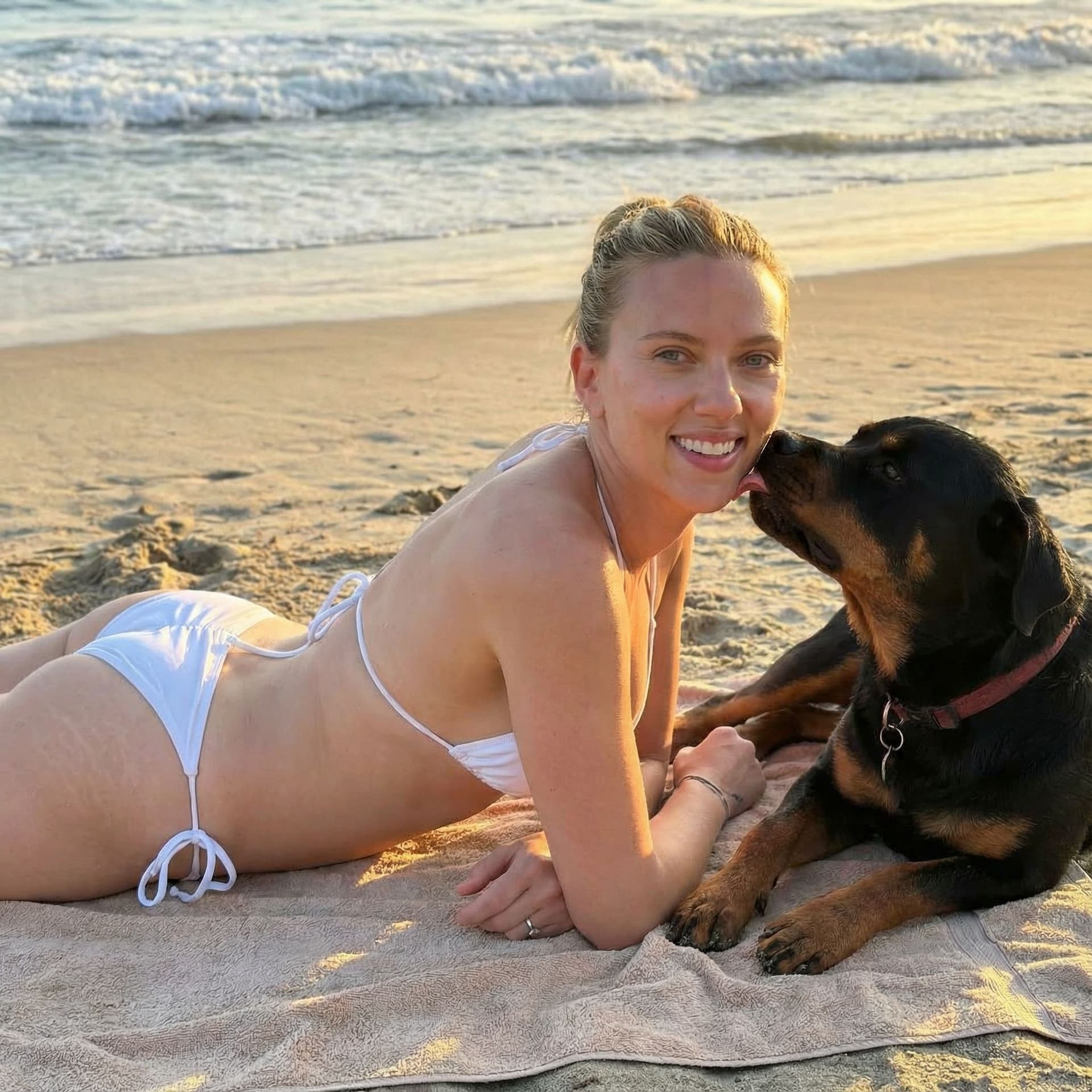 AI generated: sexy Scarlett Johansson with white wet mini bikini at the beach, lying on side at the beach with her...