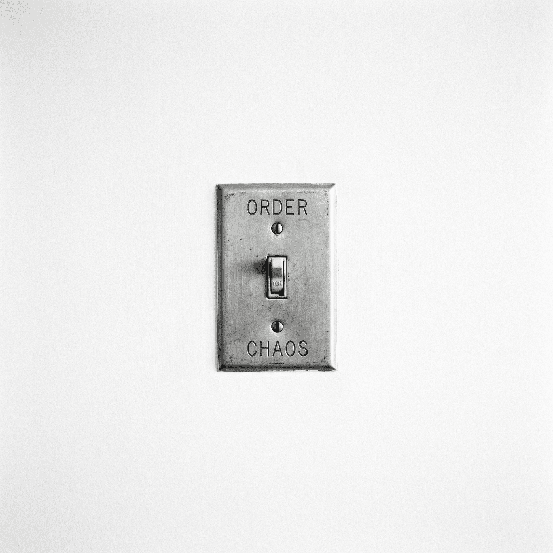 AI generated: A minimalist black and white fine art photograph of a vintage metal light switch mounted on a plain ...
