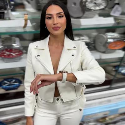 AI generated video: The image features a woman wearing a white jacket and white pants, standing on the street. She is po...