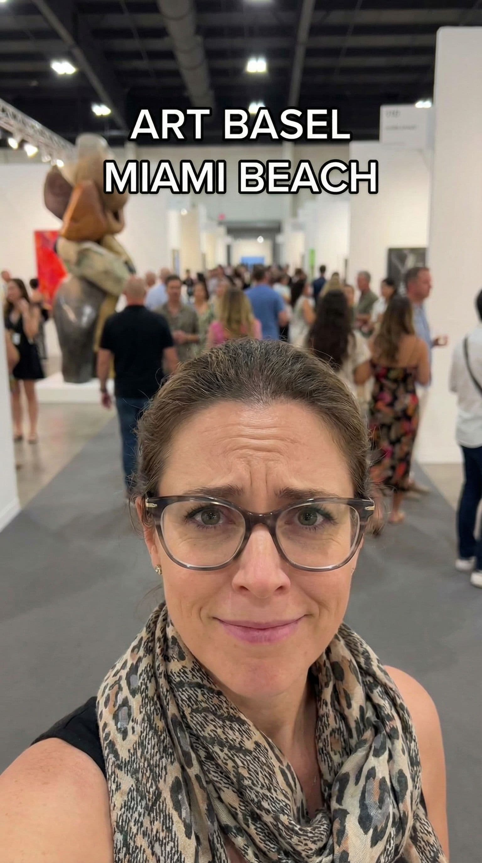 AI generated: A closeup of a person gazing directly at the camera in curiosity at art basel with a crowd behind th...