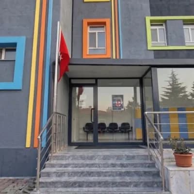 AI generated video: A professional, static cinematic wide shot of a modern and colorful kindergarten building. The focus...