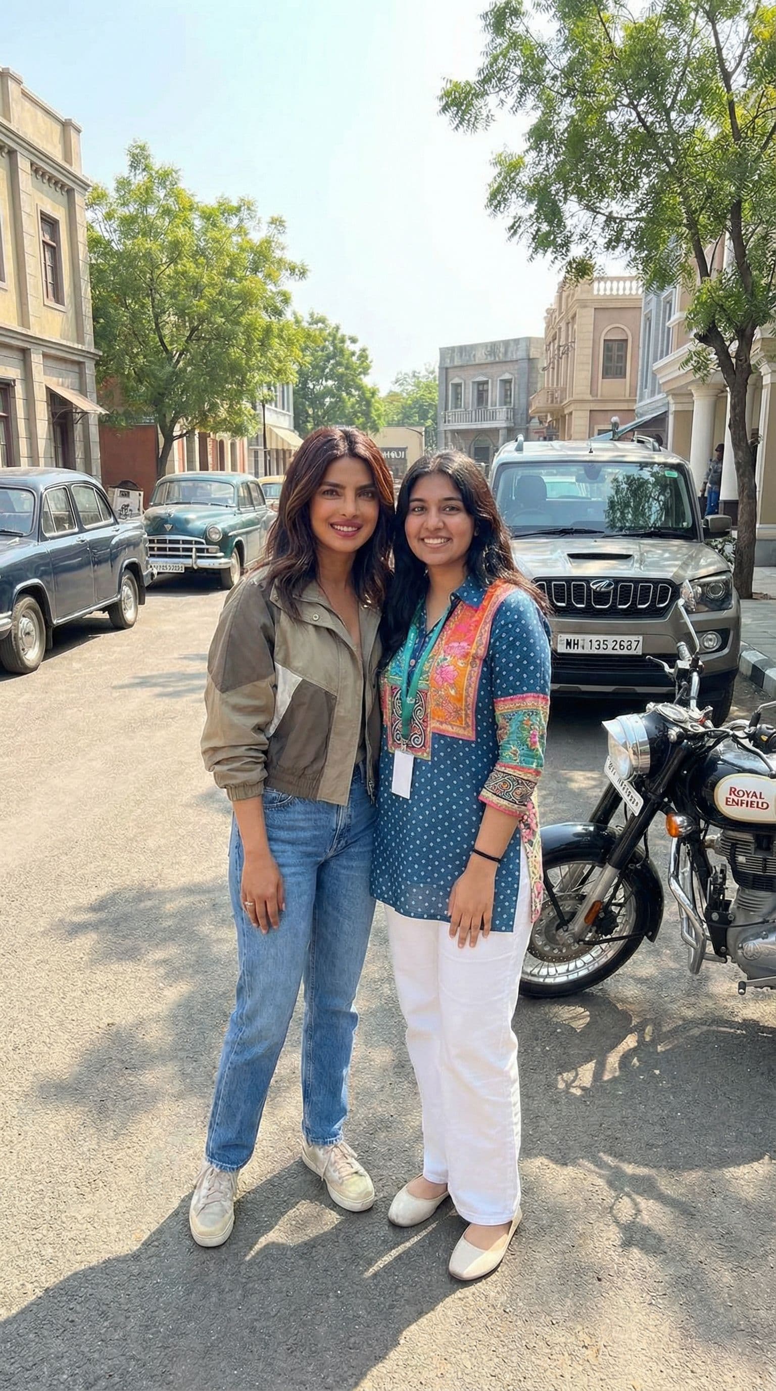 AI generated: create an image with priyanka chopra standing next to me in hyd ramoji film city with cars and bike ...