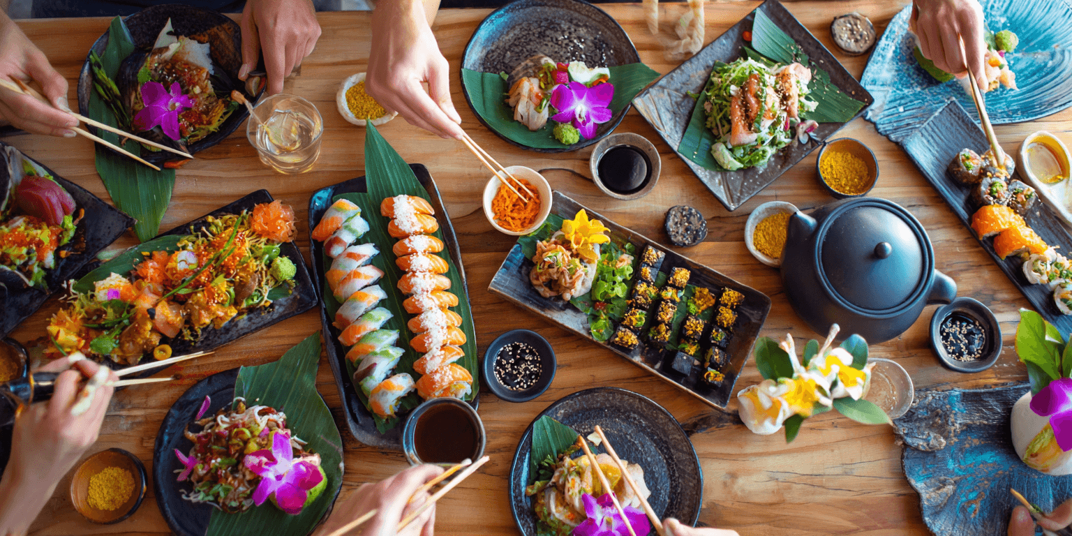 AI generated: High-angle, full shot of a dining table laden with various Asian dishes,  featuring a variety of sus...
