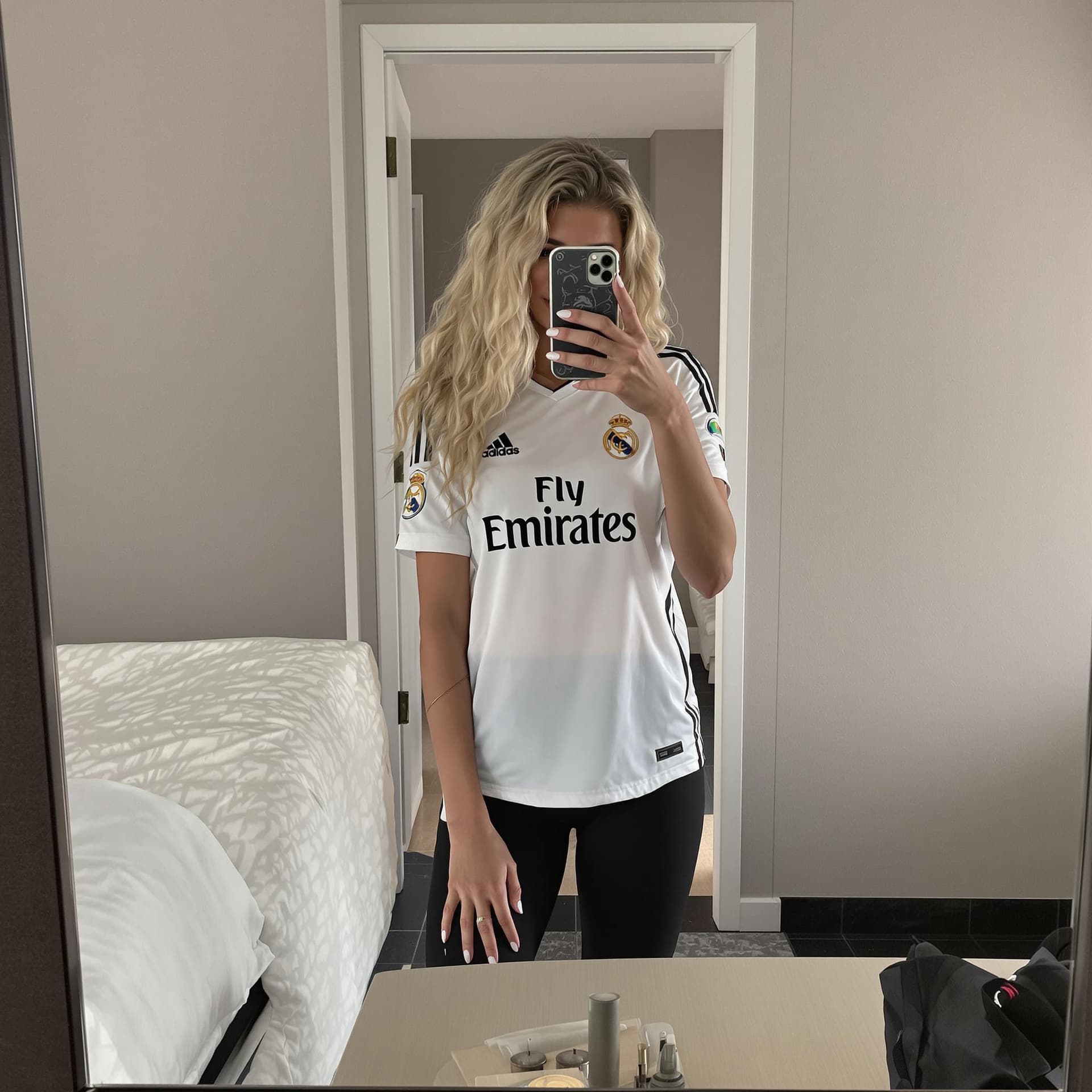 AI generated: Hot italian girl with long blonde curly hair taking a photo at a mirror in a hotel room with her det...