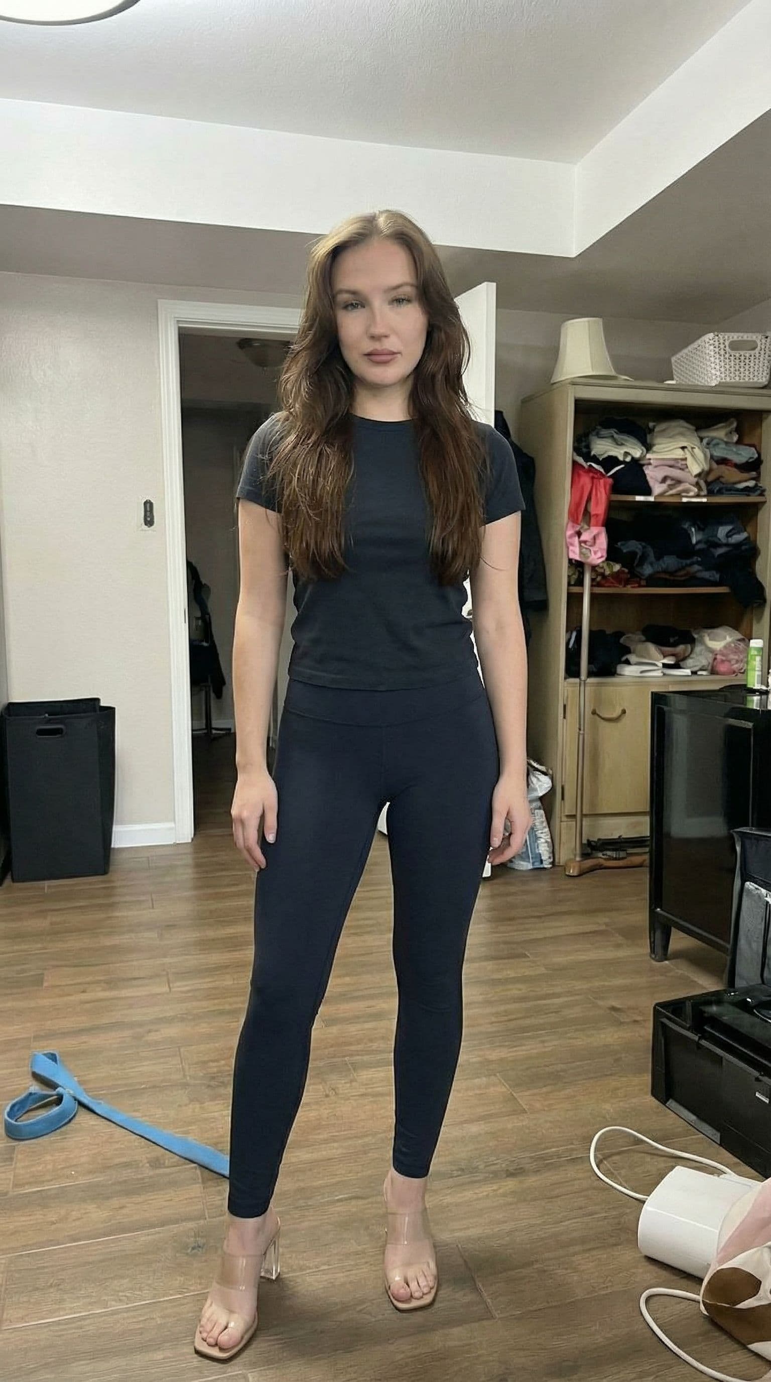 AI generated: turn into full body photo, change to leggings and clear heels, make her look younger