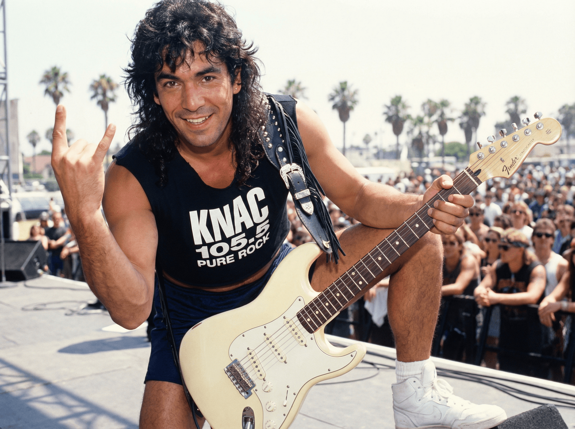 AI generated: Guitar player looks and smiles and gives a heavy metal sign with his left hand at the camera as he p...