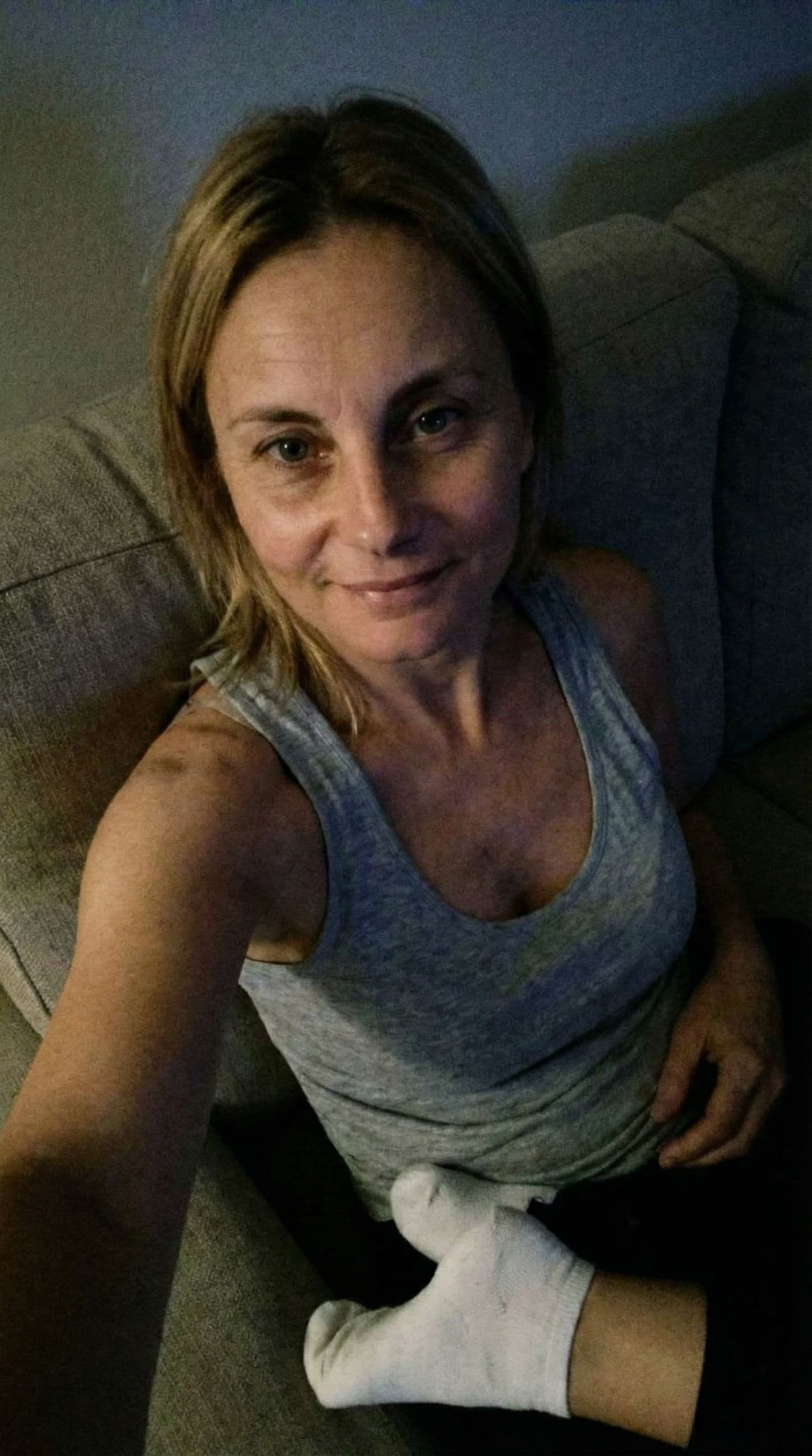 AI generated: Romantic selfie looking at me,a sloppy snapshot. Sitting on a couch at night teasing(no lights), hom...