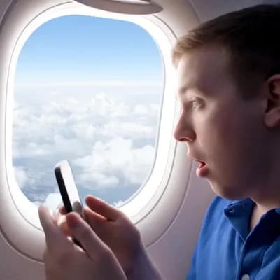 AI generated video: POV video recorded with an iPhone from the window seat of a commercial airplane. A man films the clo...