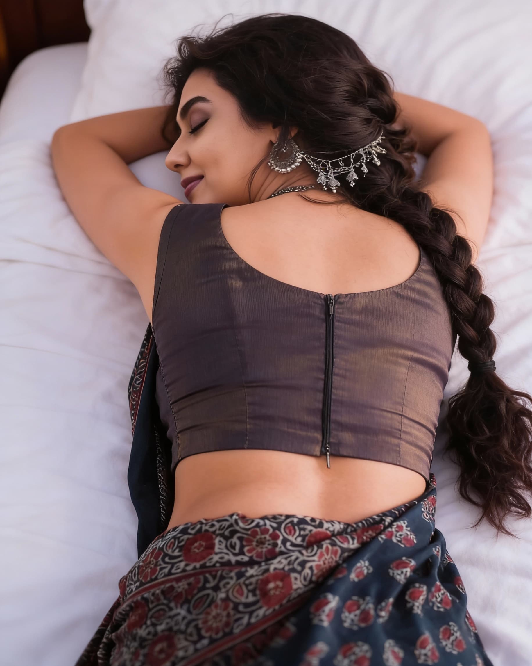AI generated: This girl is sleeping lying face down on bed in sleeveless saree blouse and showing her back body 