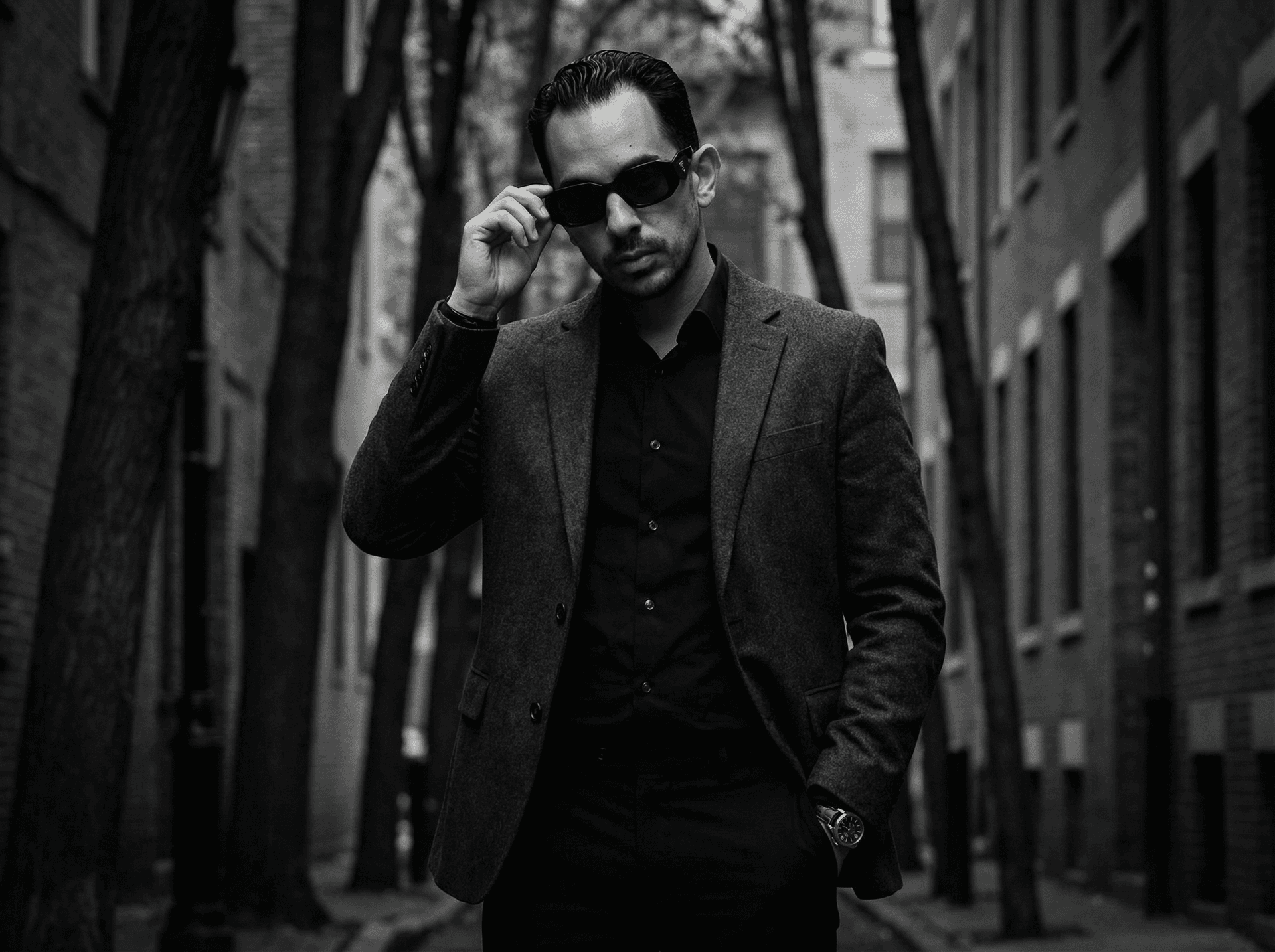 AI generated: A man in his 30s stands composed in a tree-lined urban alley, captured in sophisticated black-and-wh...