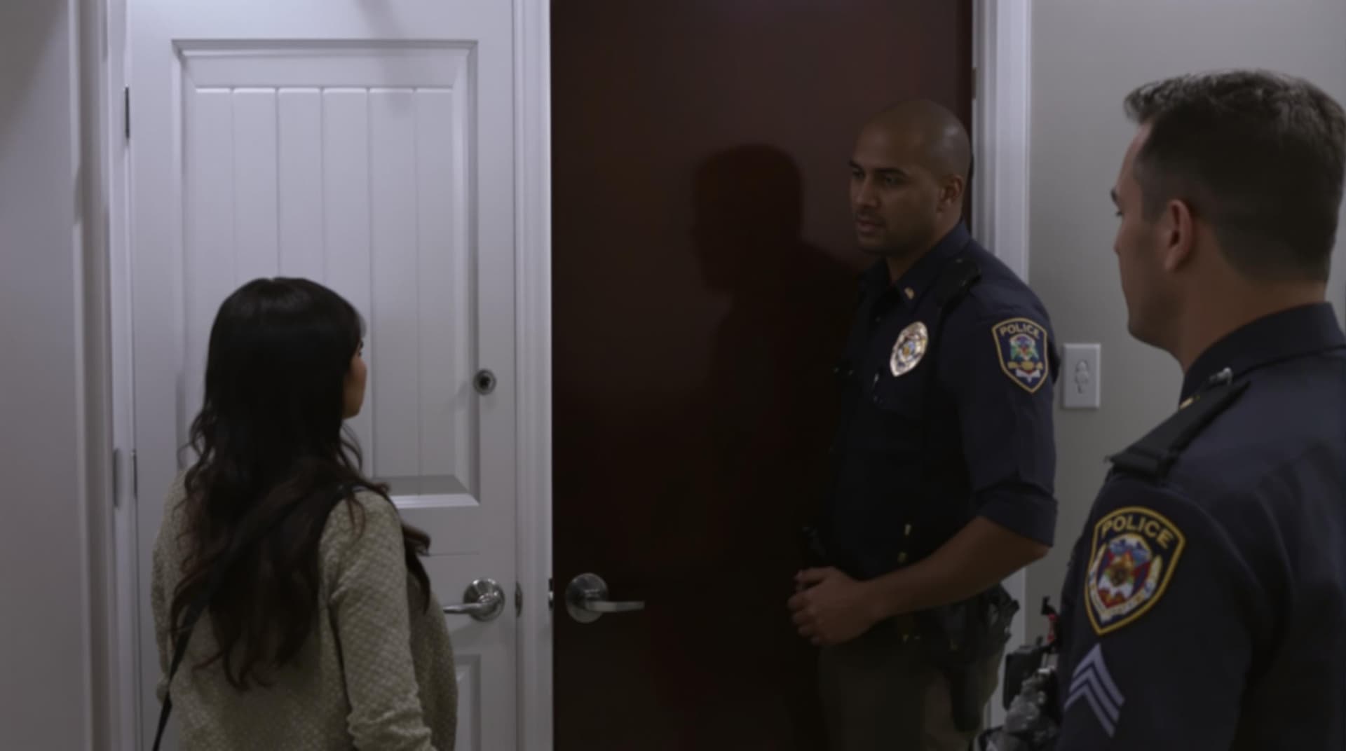 AI generated: The woman opens the door slightly. The nervous officer shifts his weight awkwardly, avoiding eye con...