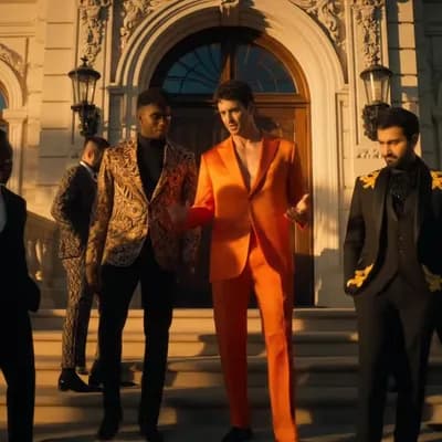 AI generated video: CREATE A VIDEO WITH A DIVERSE GROUP OF MEN DRESSED IN HIGH END DESIGNER CLOTHING GATHERED AT THE VER...