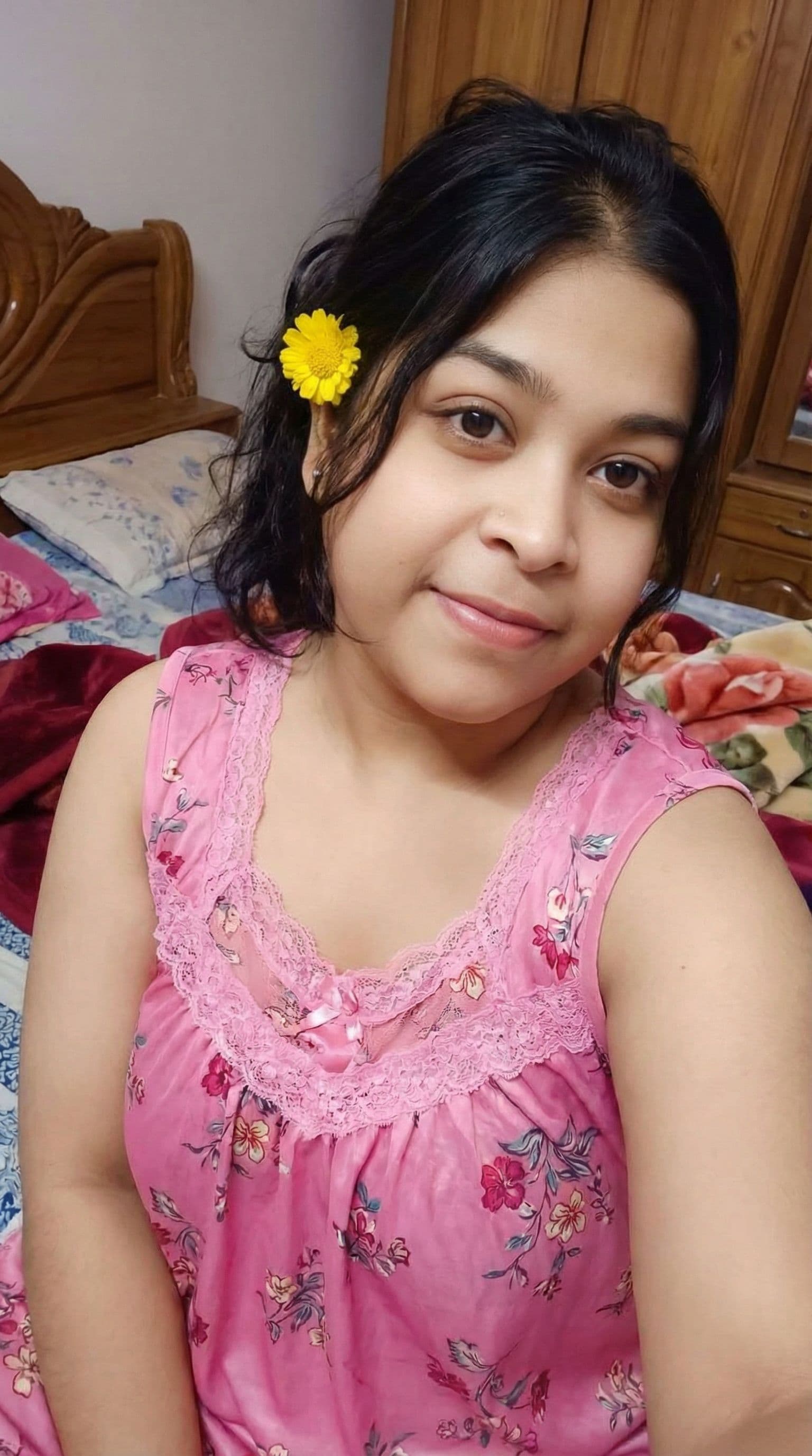 AI generated: The women wearing a hot lacy sleeveless floral print short nighty and sitting on bed in the bedroom