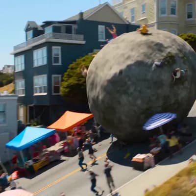 AI generated video: 15-second cinematic action-comedy sequence, photorealistic. A massive stone boulder rolls down a ste...