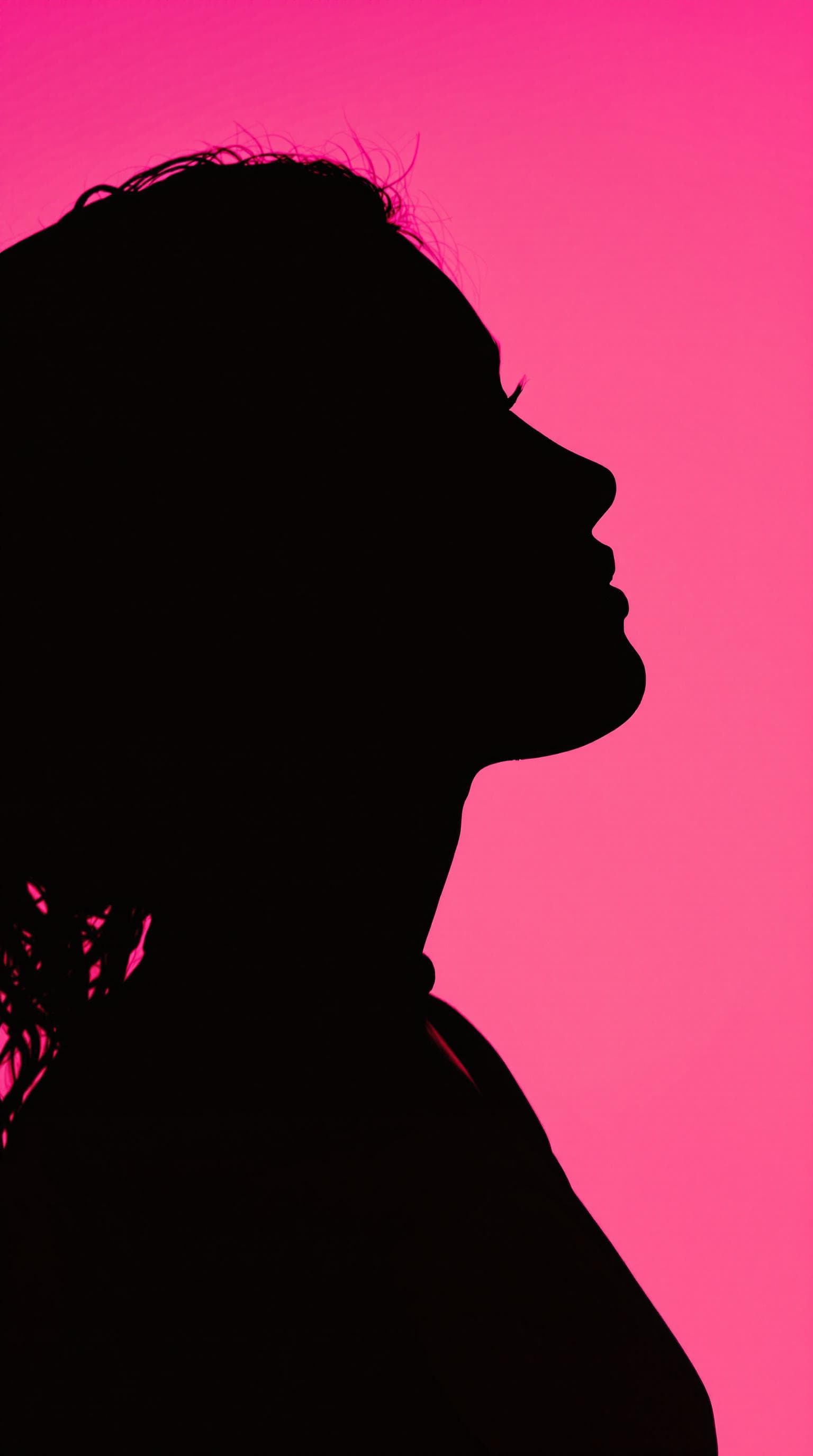 AI generated: photography, portrait of contrast, profile silhouette of a woman, vibrant hot pink backdrop, visuali...