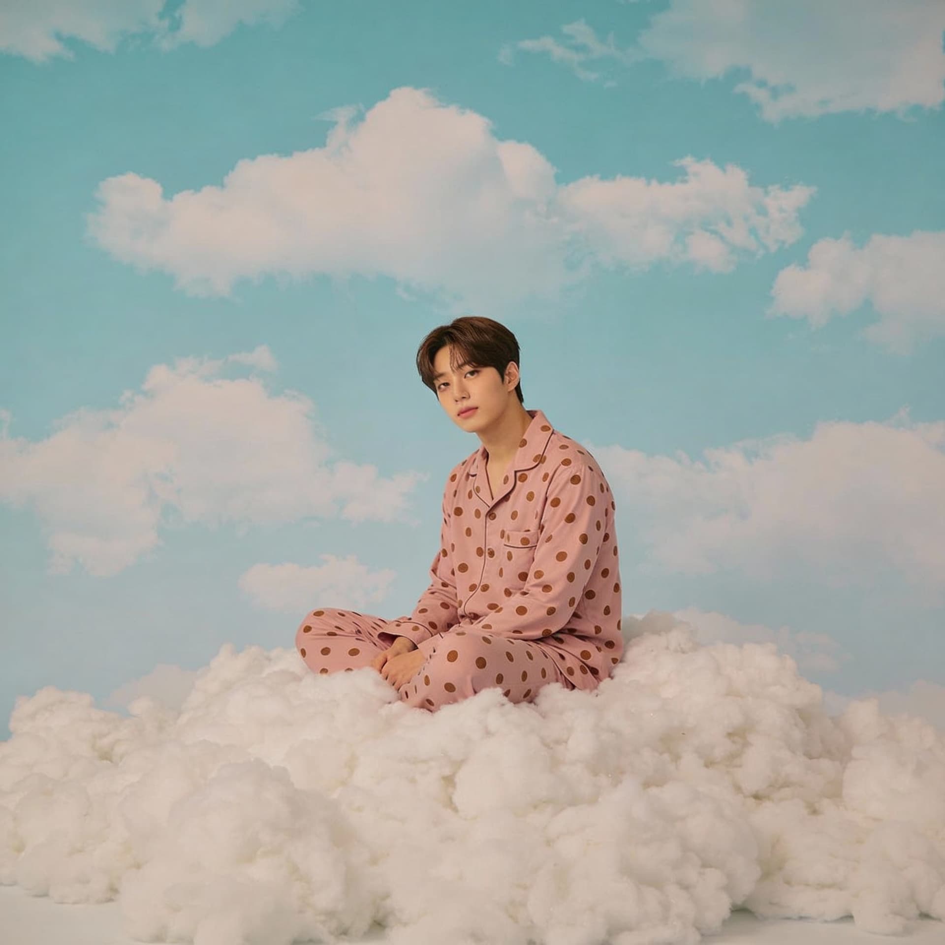AI generated: A photo of WonYoung(korea Idol) sitting on top of white fluffy clouds wearing pink pajamas with brow...