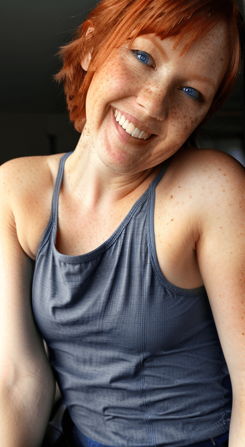 AI generated: beautiful lady, freckles, big smile, blue eyes, short ginger hair, dark makeup, wearing a thin blue ...