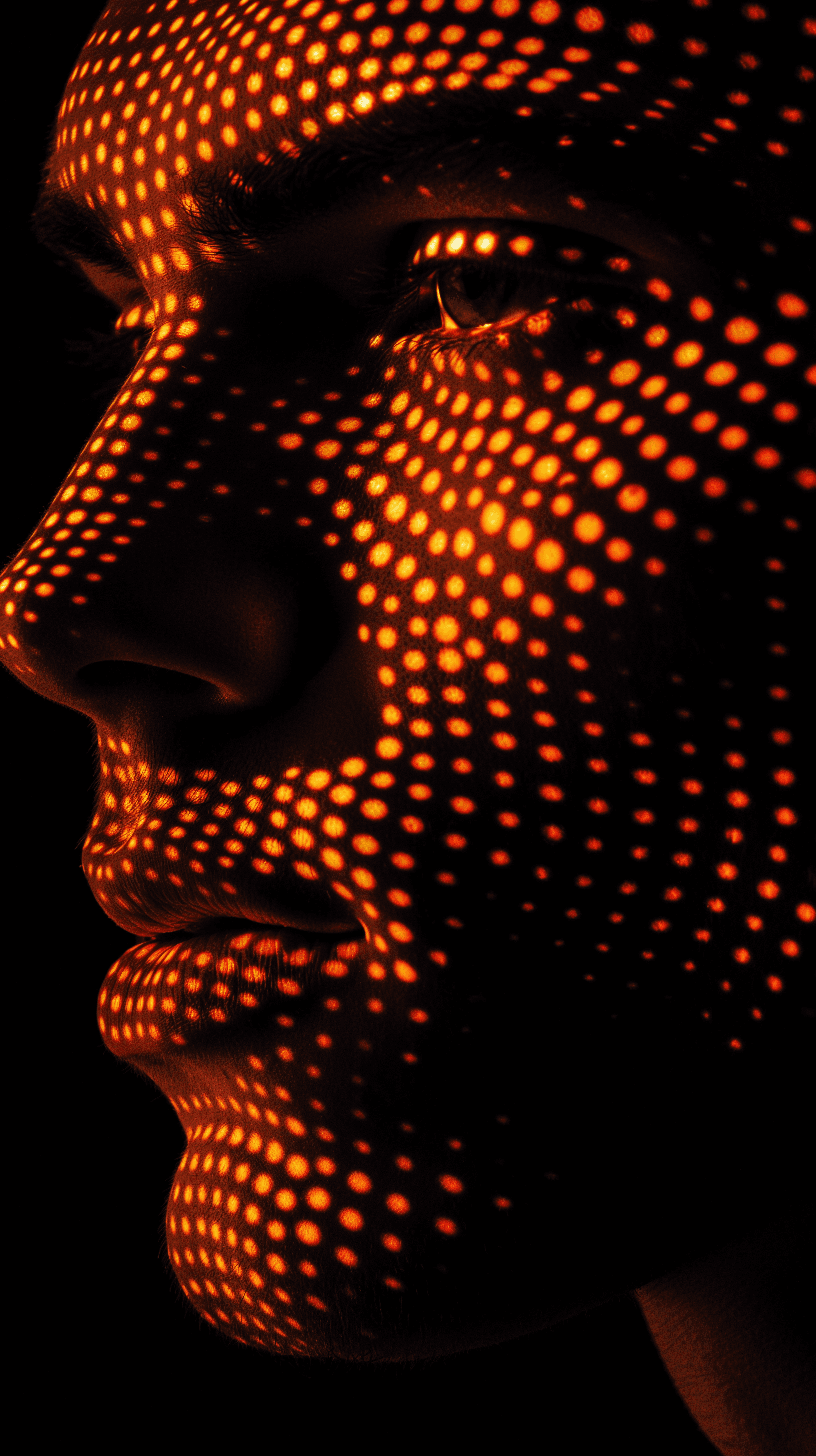AI generated: abstract image, man face using a dot matrix expression, black background, face is composed of orange...