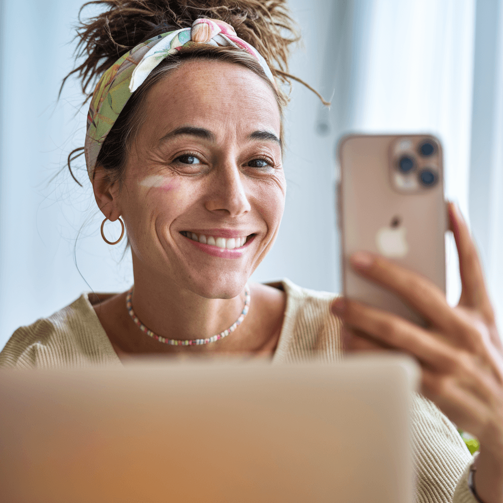AI generated: A pretty woman influencer, with a warm and genuine smile, is sitting at her desk with her laptop ope...
