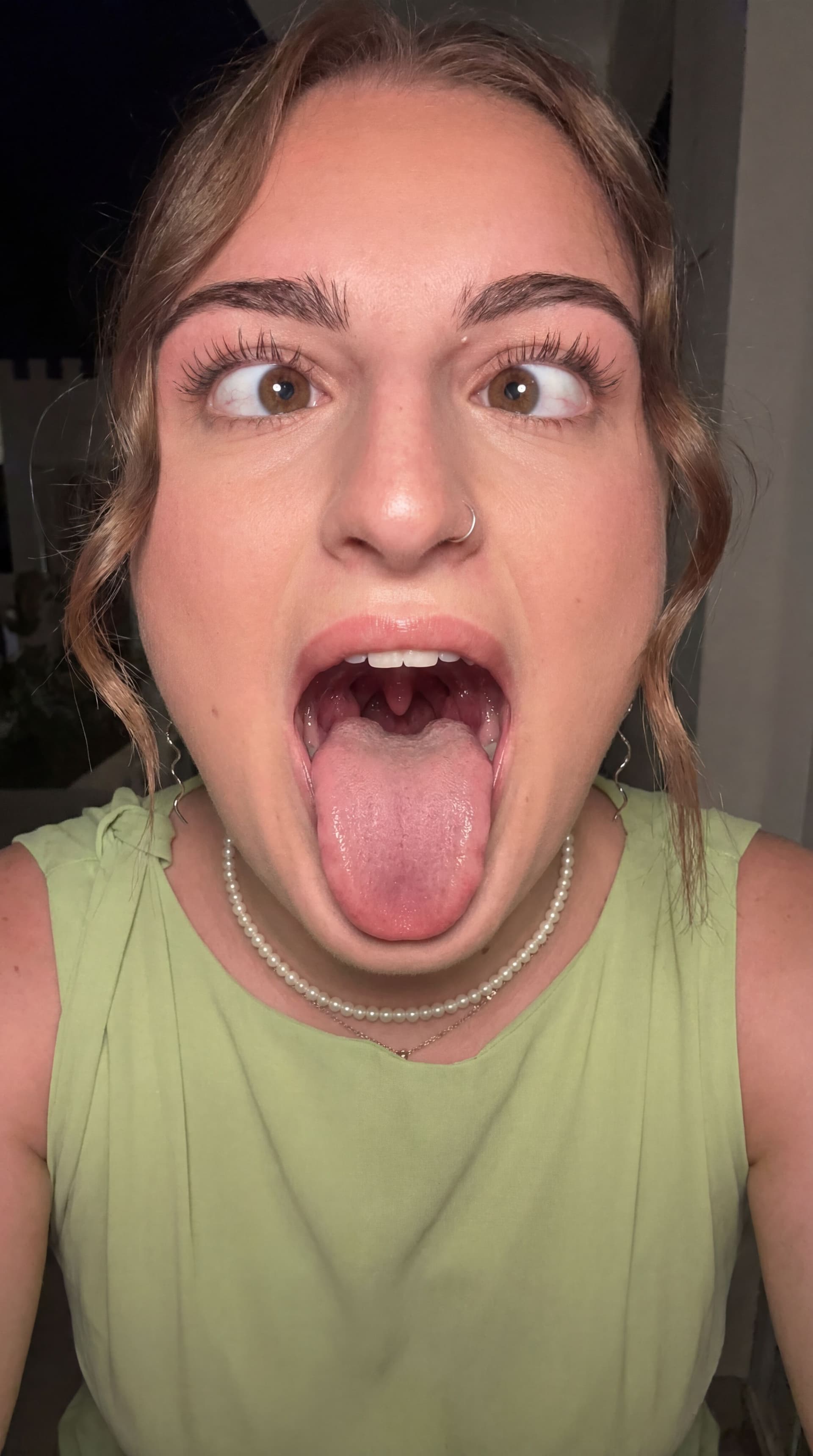 AI generated: Generate a photo of me sticking my tongue out my mouth wide open so you can see my tonsils at the ba...
