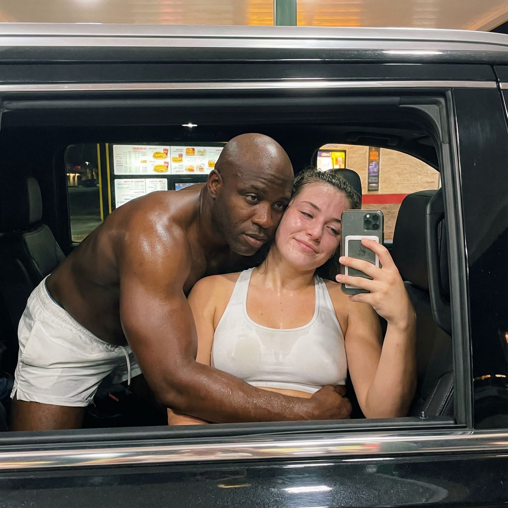 AI generated: This girl is sitting in the passenger seat of a car, taking a picture of herself and her boyfriend i...