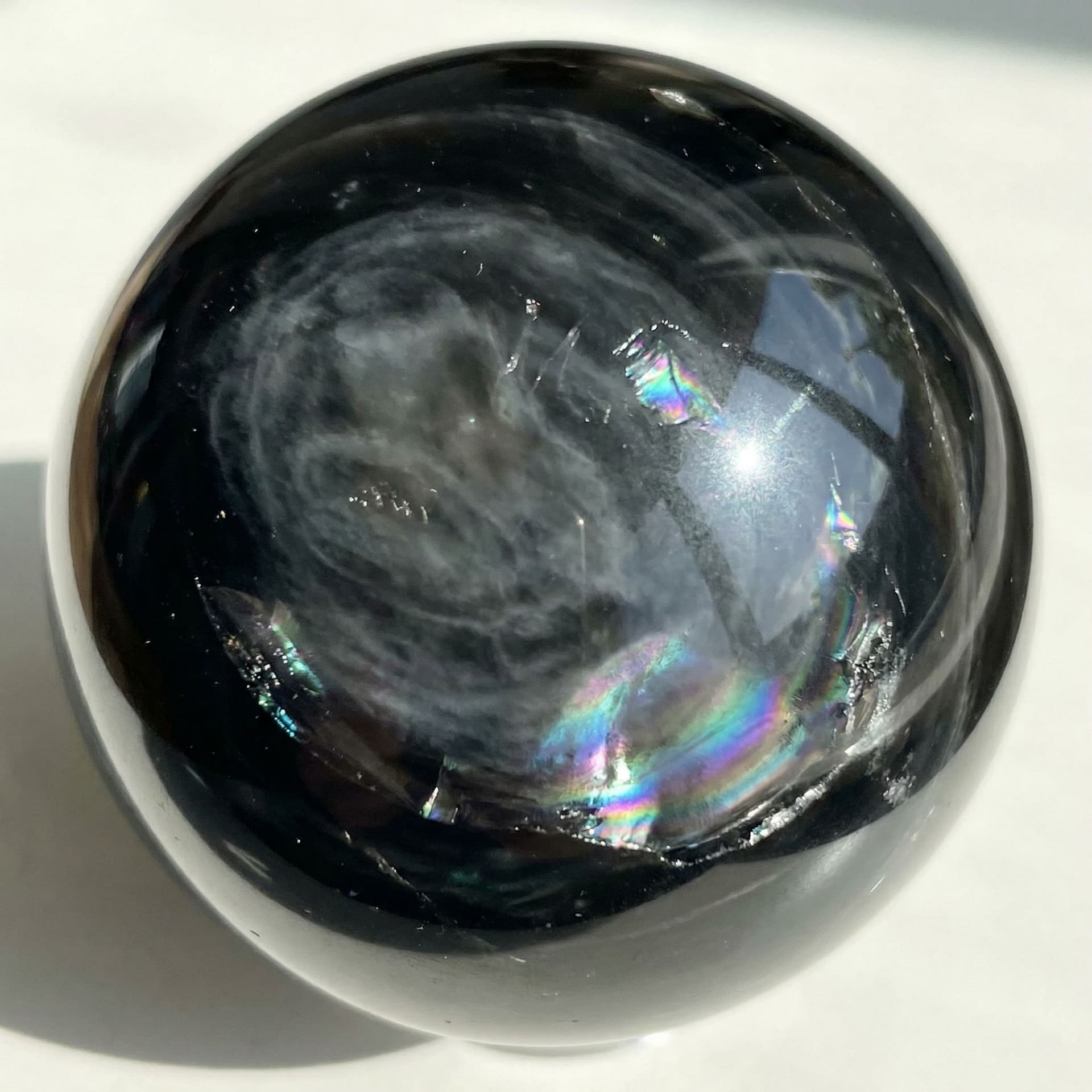 AI generated: Black obsidian with grey whisps flowing through it like clouds and it has a shine like opal
