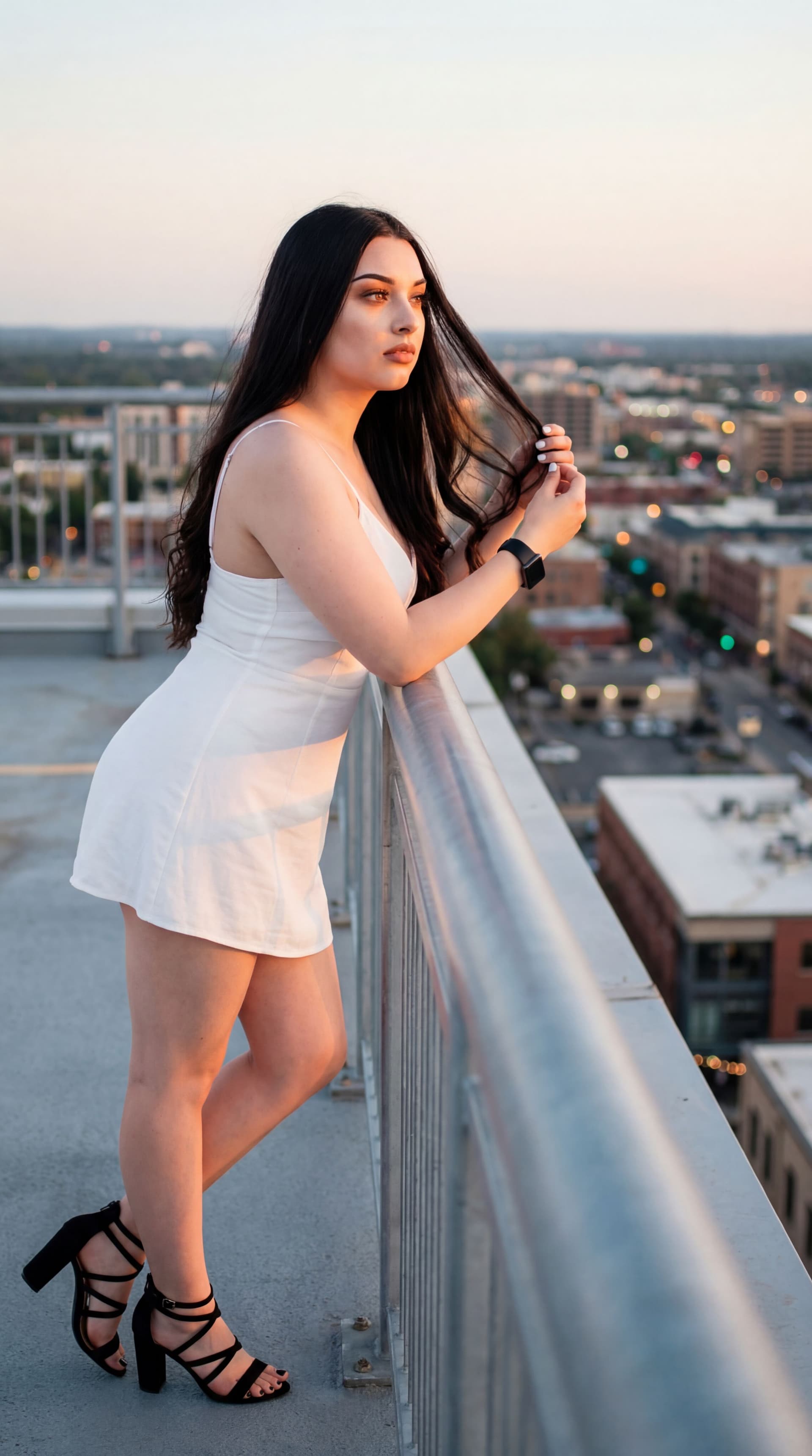 AI generated: On a quiet rooftop at golden hour, with the sprawling cityscape twinkling below, a stylish woman in ...