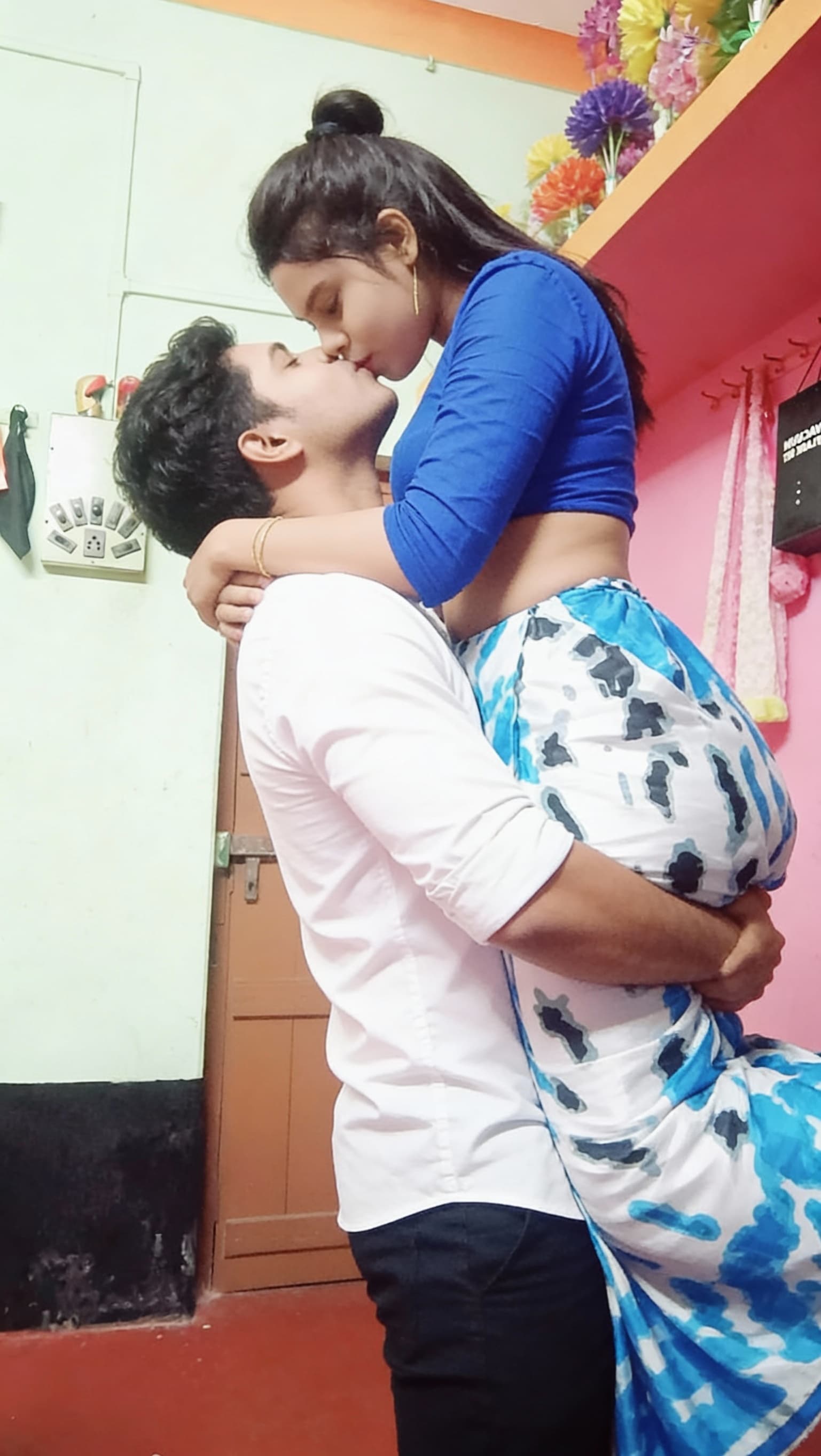 AI generated: The man lifting the women on his arms and kissing the lips. The girl face same.