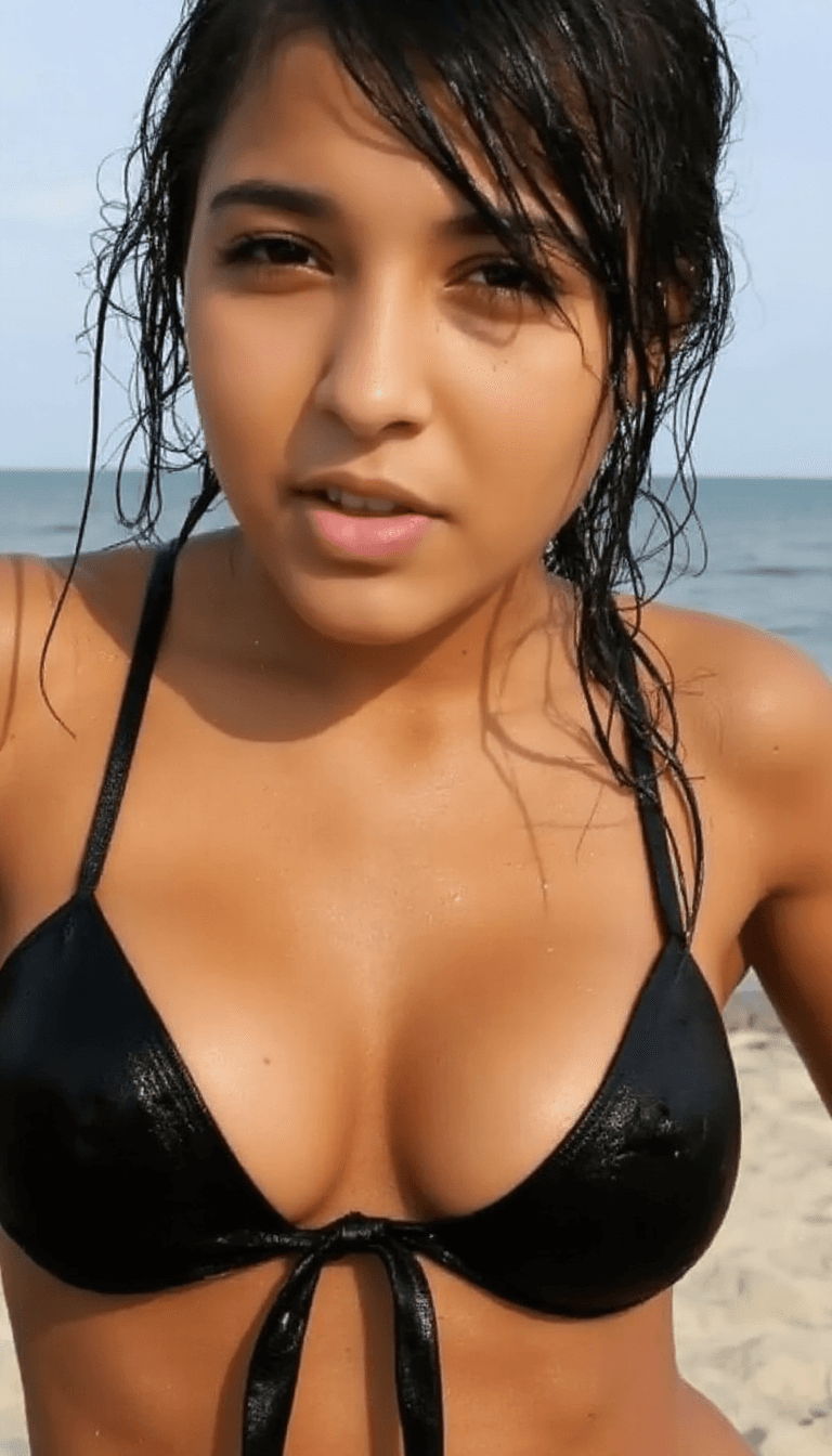AI generated: Create a close-up portrait of a fit adult woman on a beach, wearing a black bikini top with thin str...