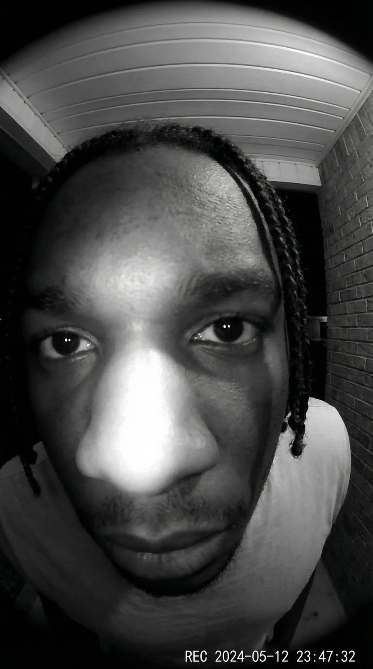 AI generated: Ultra-realistic doorbell camera POV, extreme fisheye distortion, face extremely close to the lens, e...